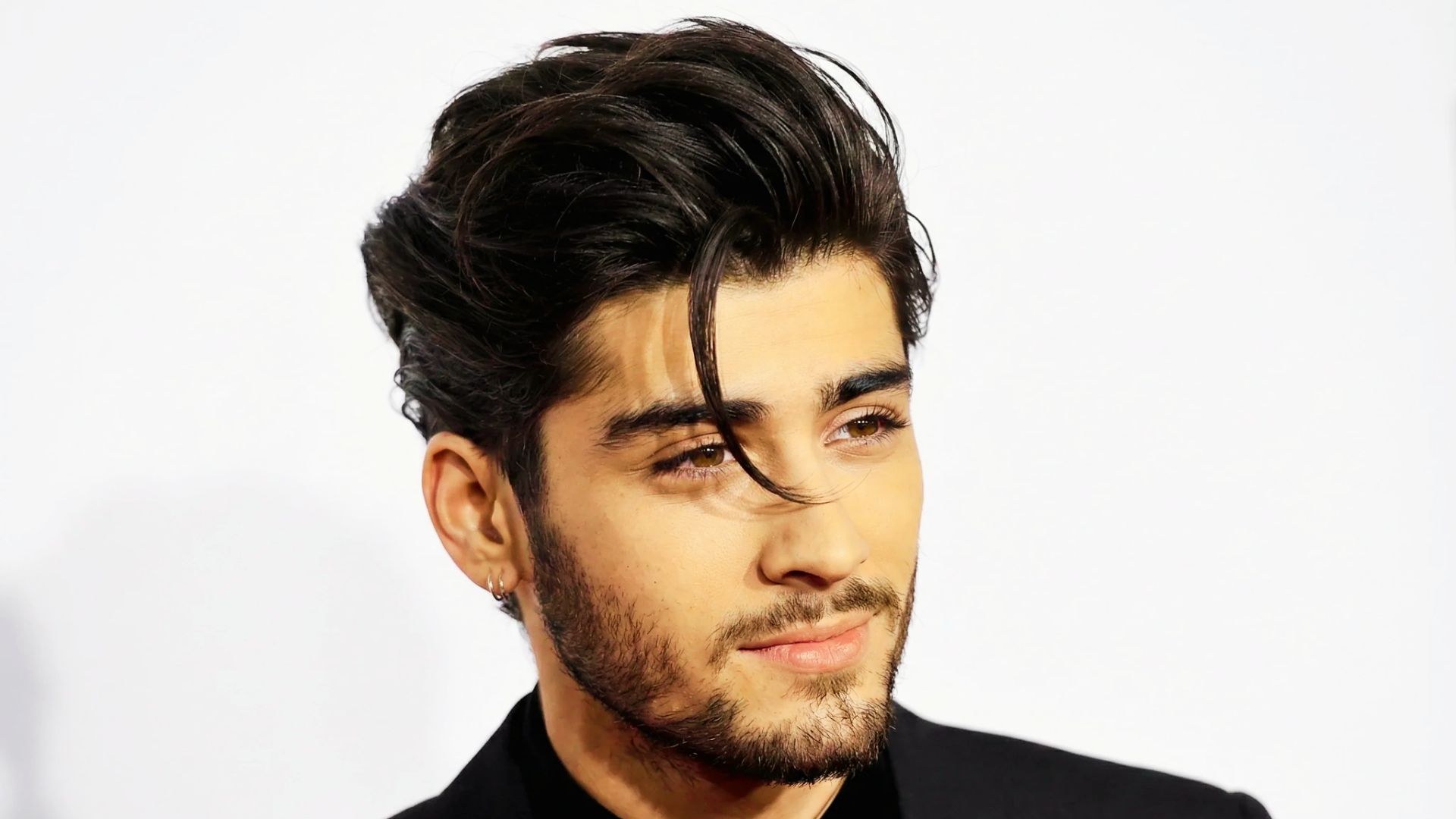 Zayn Malik with a stylish long on top haircut, showcasing his handsome features and confident expression.
