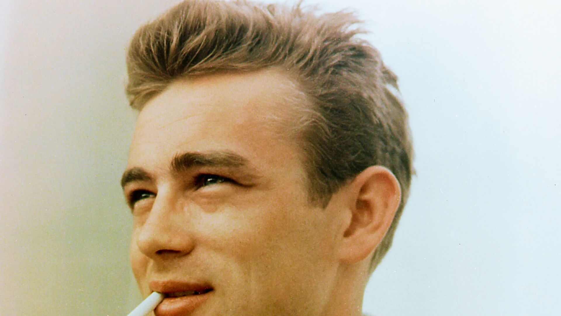 James Dean a cigarette in his mouth, showcasing a modern twist on a classic hairstyle.