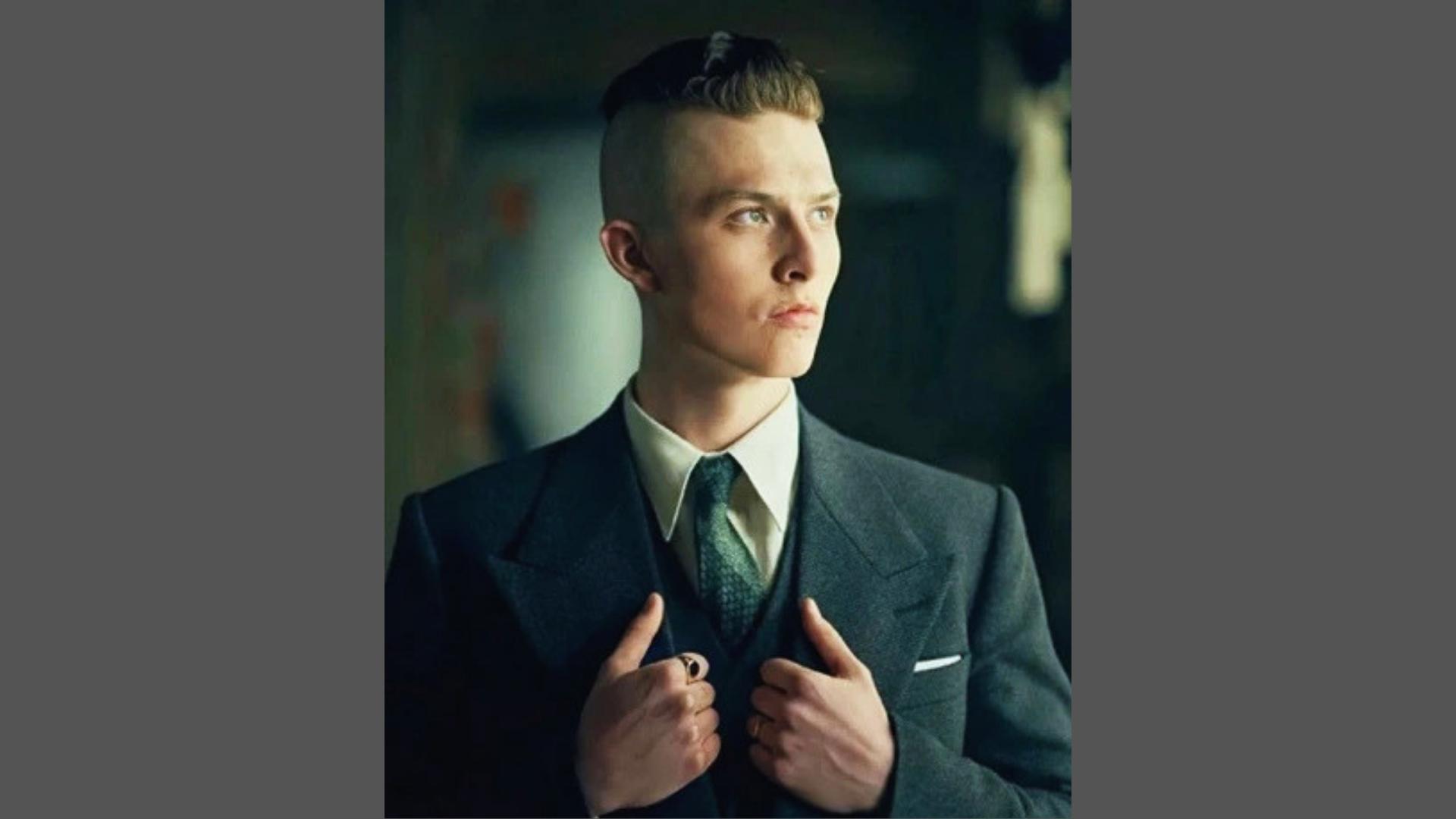 Finn Shelby from Peaky Blinders wearing three-piece suit with classic 1920s undercut haircut and side-swept top