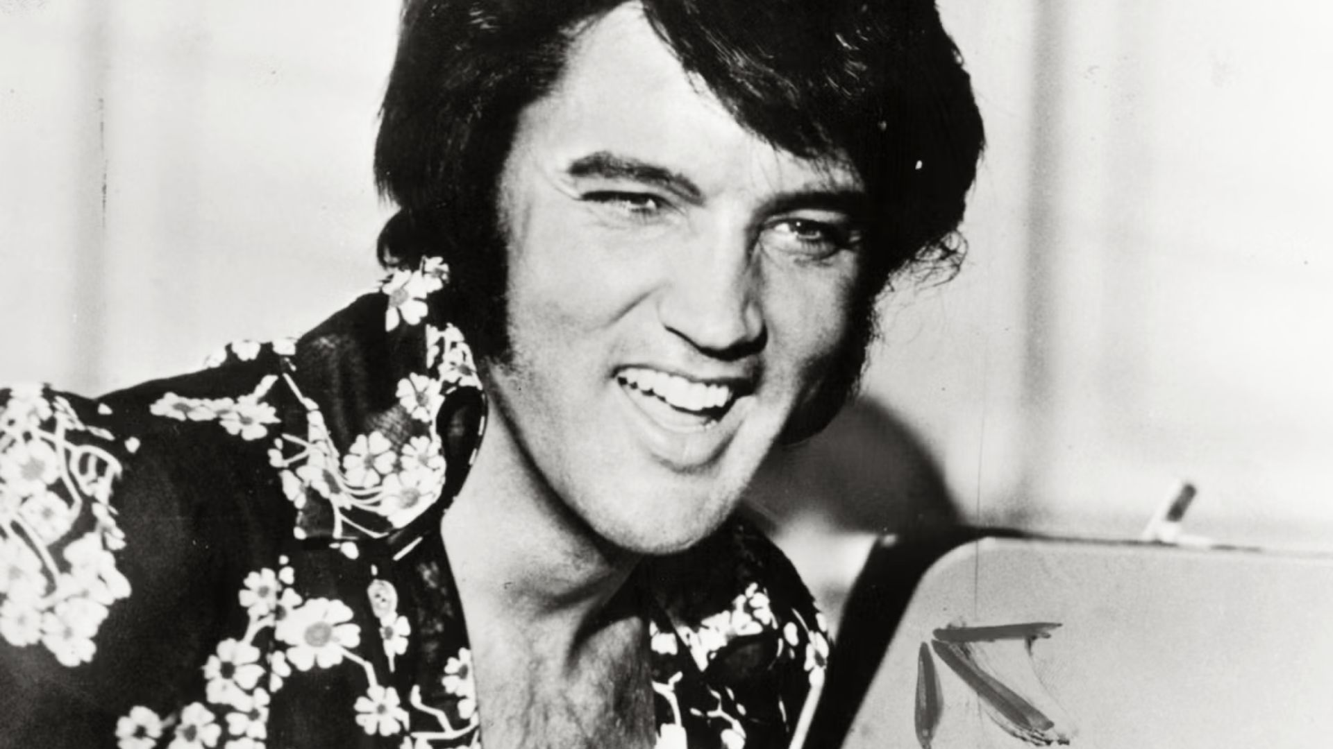 Black and white photo of Elvis Presley showcasing his iconic textured pompadour hairstyle.