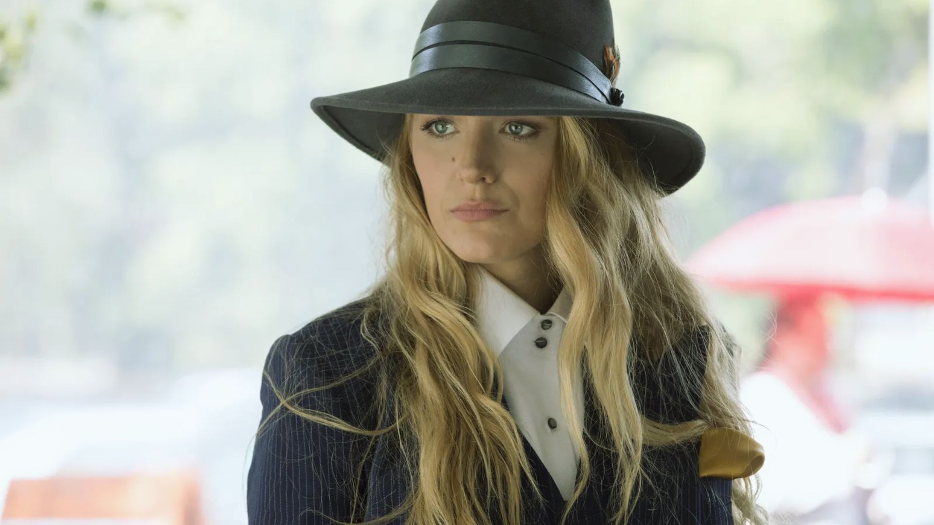 "A woman in a stylish hat and suit jacket, exuding confidence and elegance."