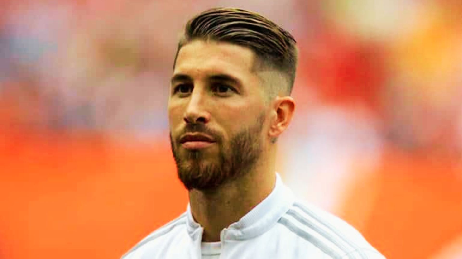 Sergio Ramos with a beard wearing a white shirt, styled with a comb-over haircut.