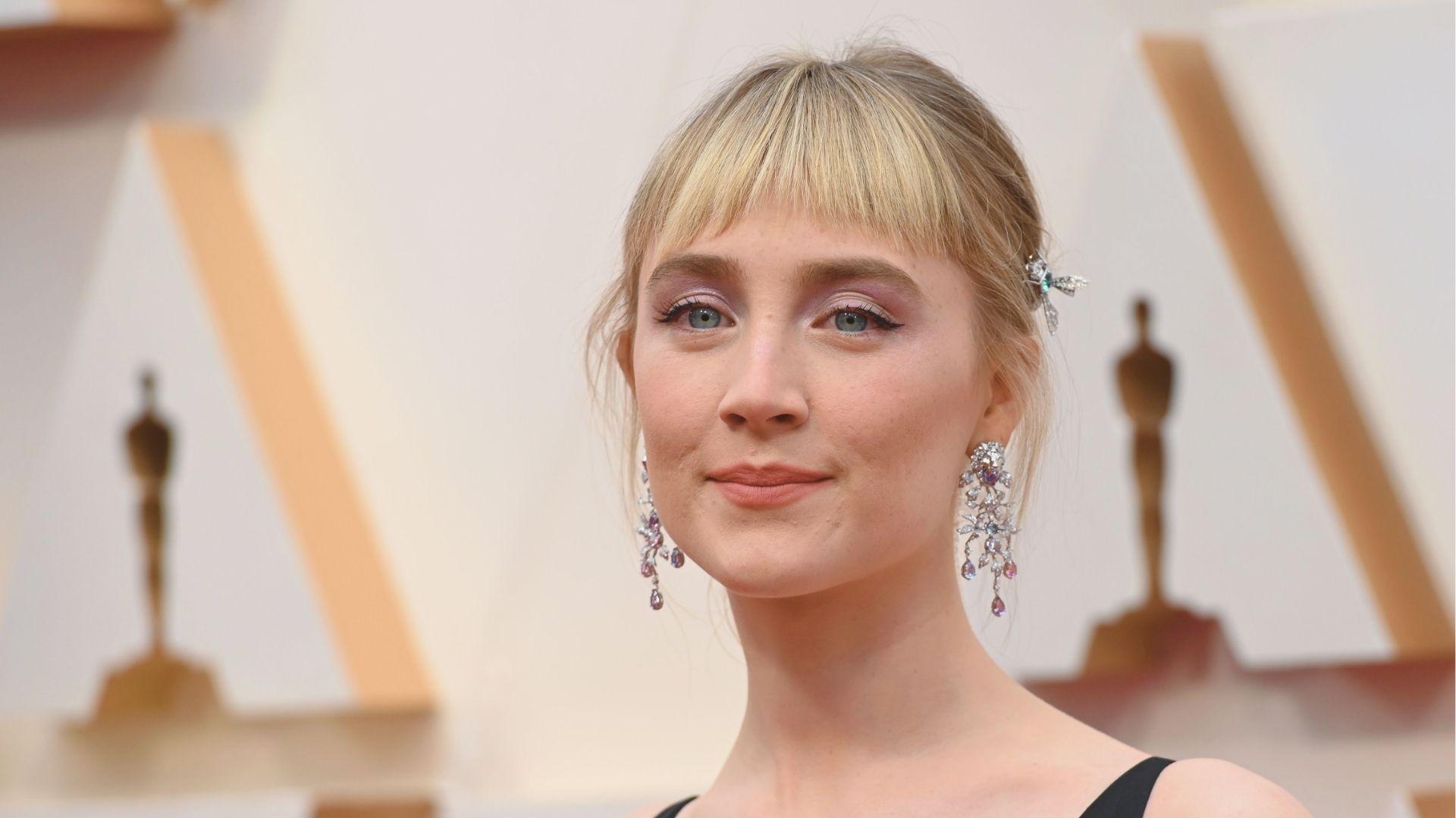 Saoirse Ronan on the Oscars red carpet with a blunt ’70s-style fringe and low updo.