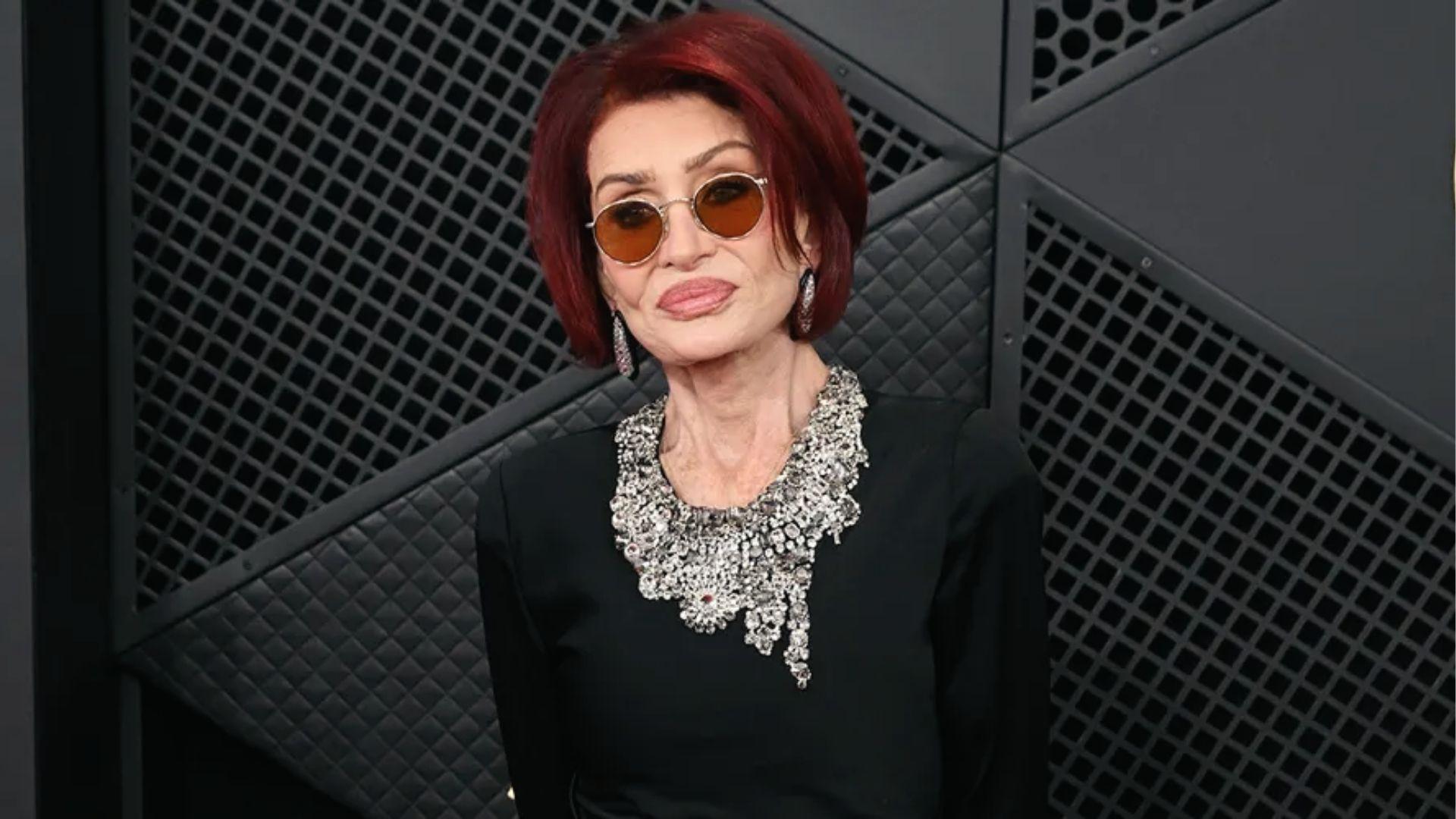 Sharon Osbourne wears black dress with statement crystal collar and amber round sunglasses
