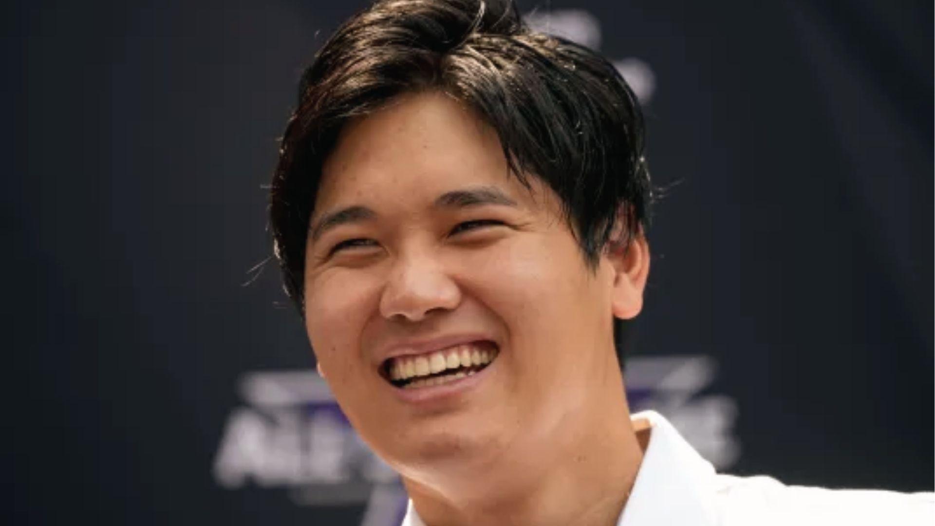 Shohei Ohtani laughing at event with damp slicked-back haircut and volume