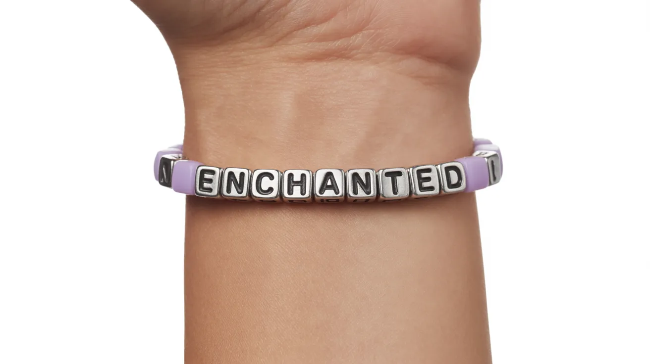 wrist wearing a lavender and silver beaded bracelet with cube letter beads spelling ENCHANTED clearly in uppercase.