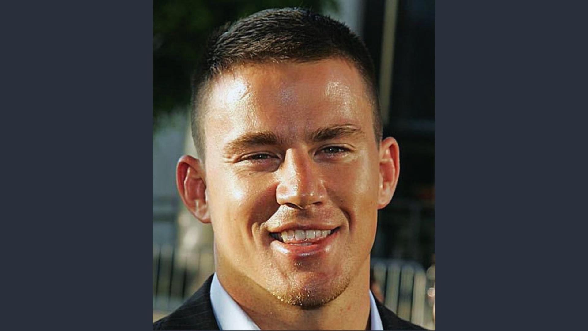 Channing Tatum smiles outdoors sporting a tight high-and-tight buzz cut with short stubble, a clean military-influenced style.