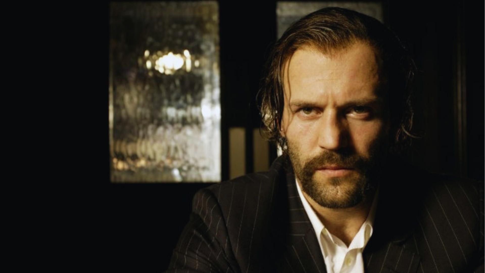 Jason Statham as a younger actor with longer, slicked-back hair and sideburns, before embracing his bald style.