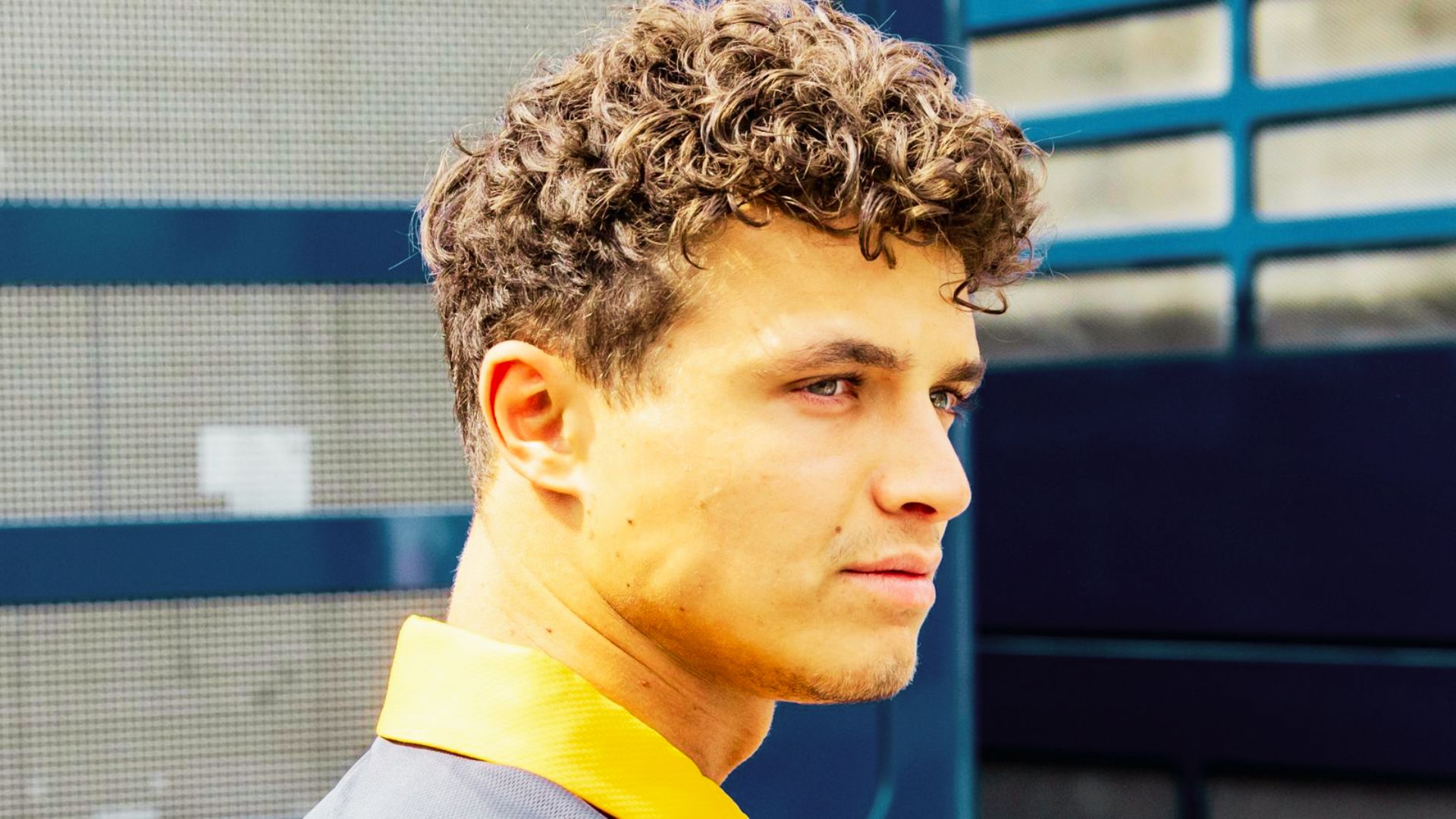 Side profile of Lando Norris showing the shape of his curly cut.