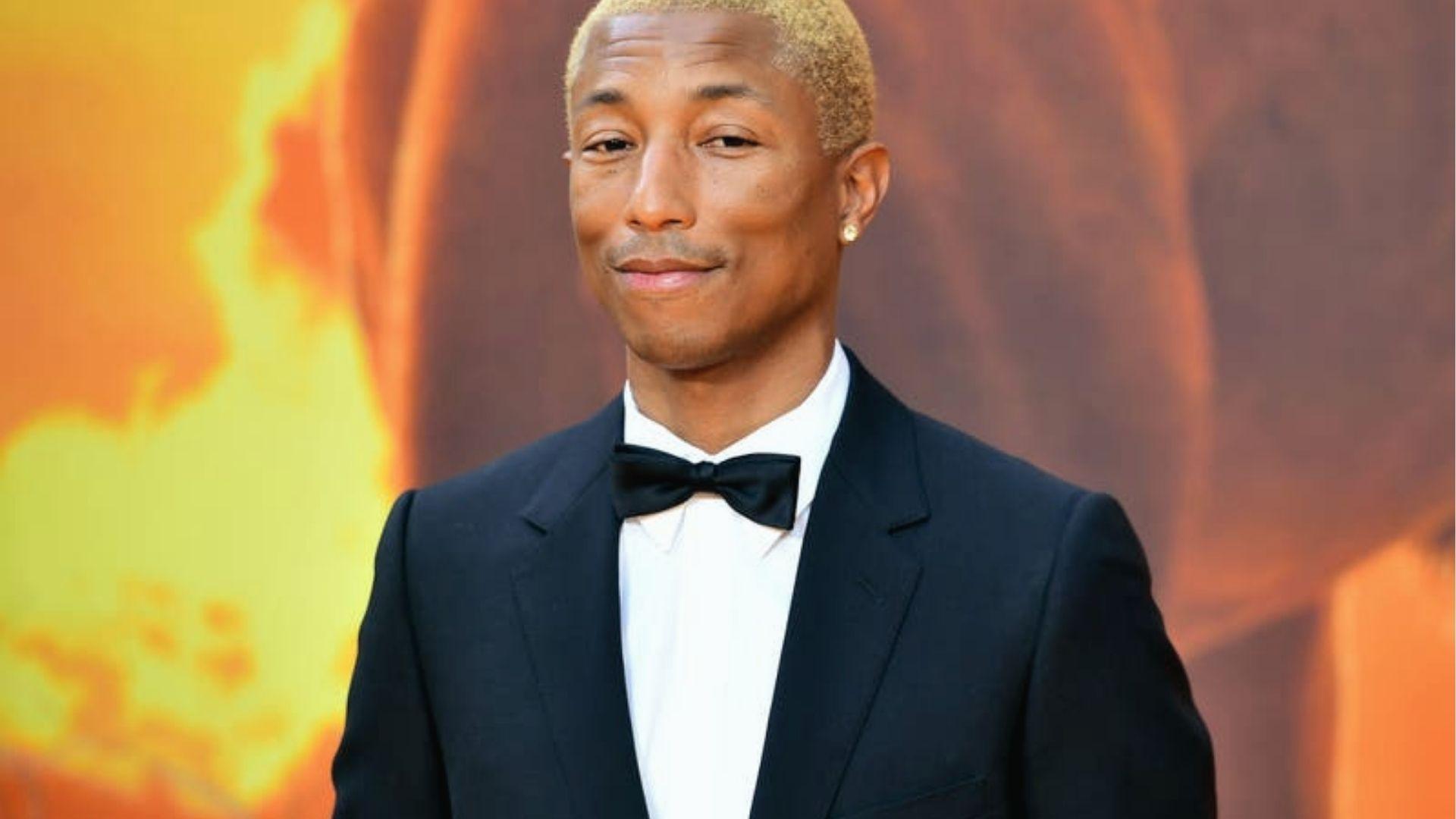 Pharrell Williams in classic black tuxedo with bow tie, bleached hair, red carpet event