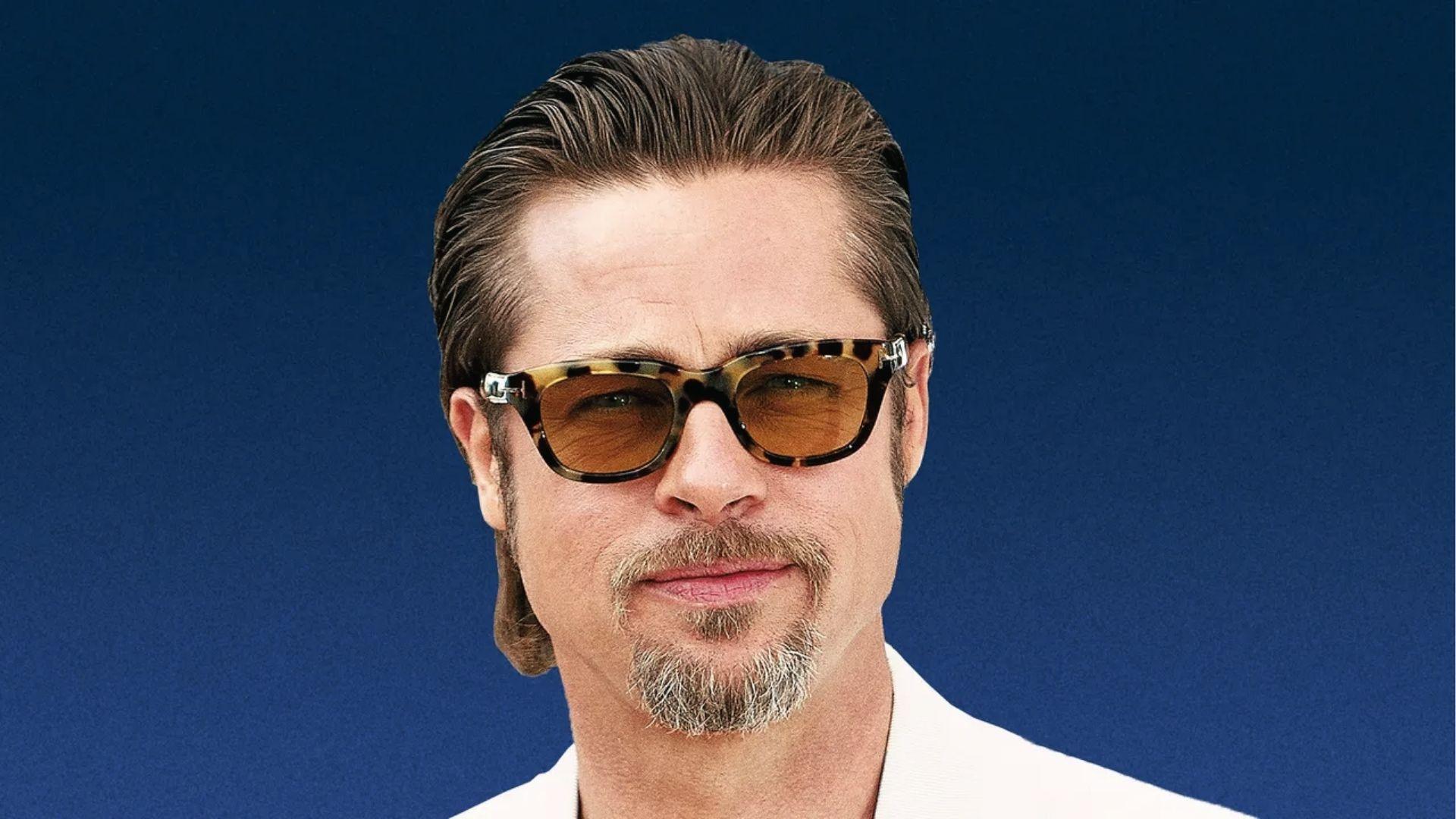 Brad Pitt with slicked back medium hair and tortoise sunglasses, white jacket, blue backdrop