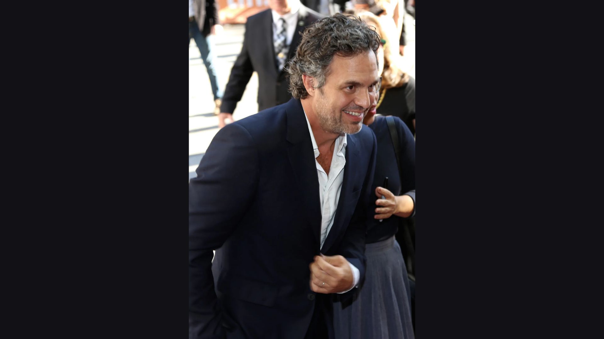 "A man in a suit and tie smiles warmly, exuding confidence and professionalism."