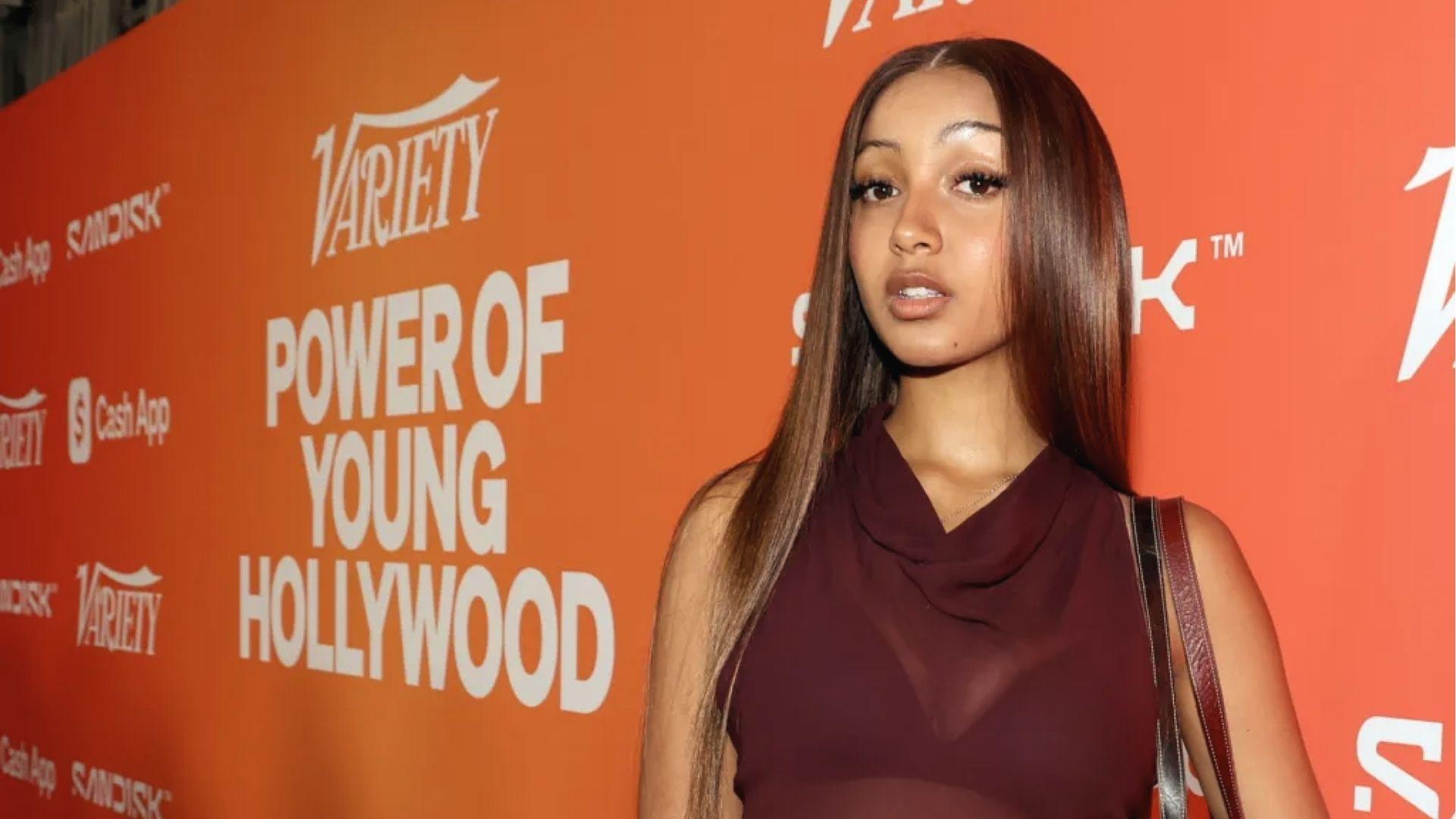 PinkPantheress in maroon sheer dress at Variety event, sleek hair, soft glam.