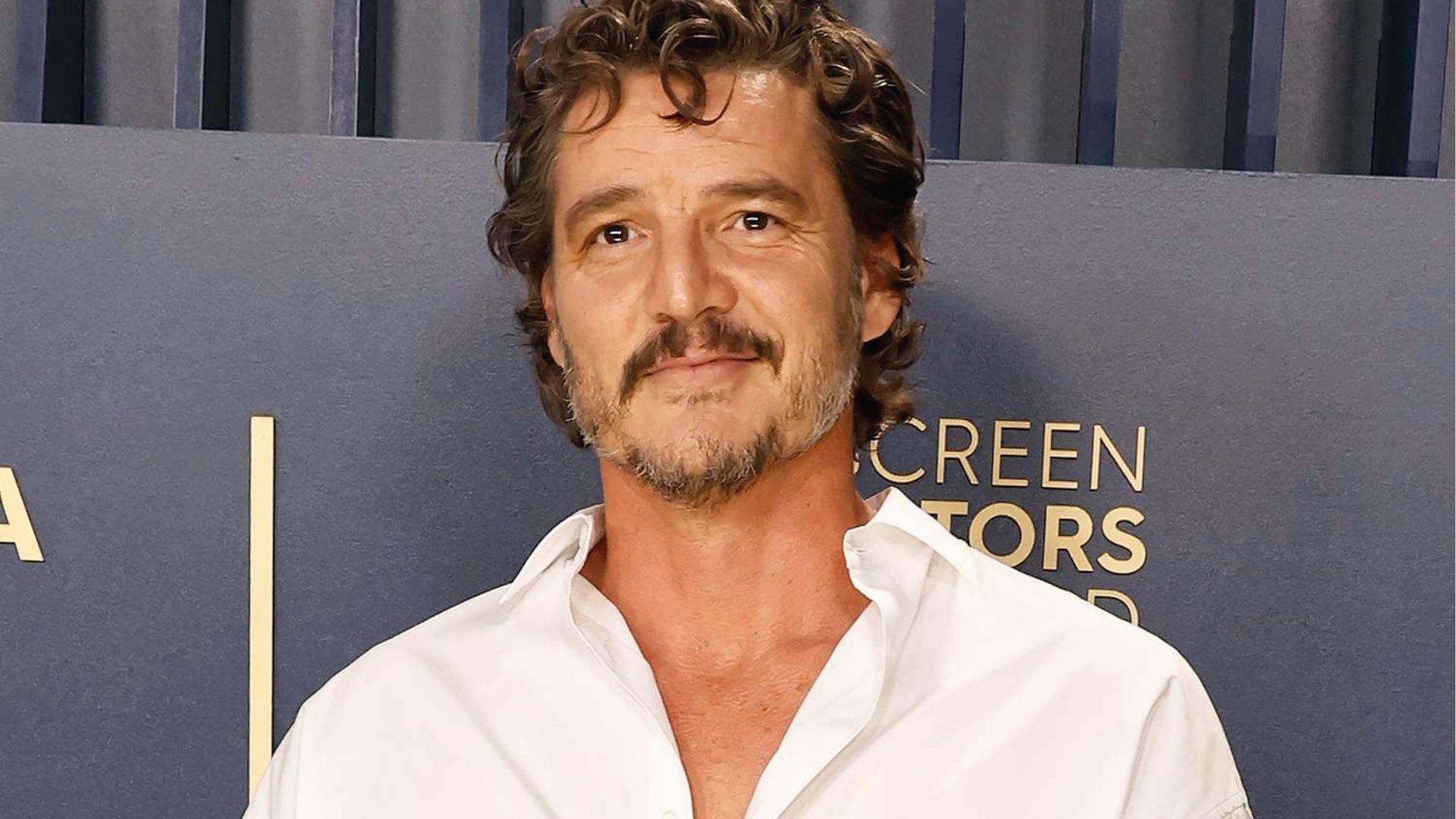 Pedro Pascal with curly medium haircut and mustache wearing white shirt at SAG Awards red carpet