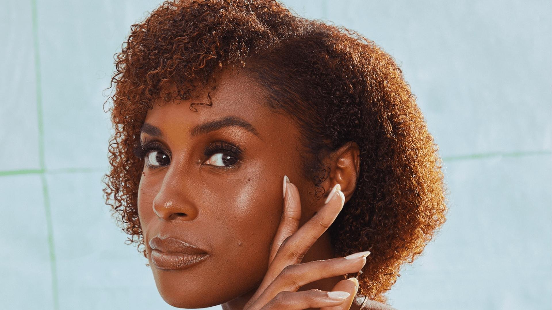 Close-up of Issa Rae with a defined curly afro and side part, showcasing natural texture and volume.