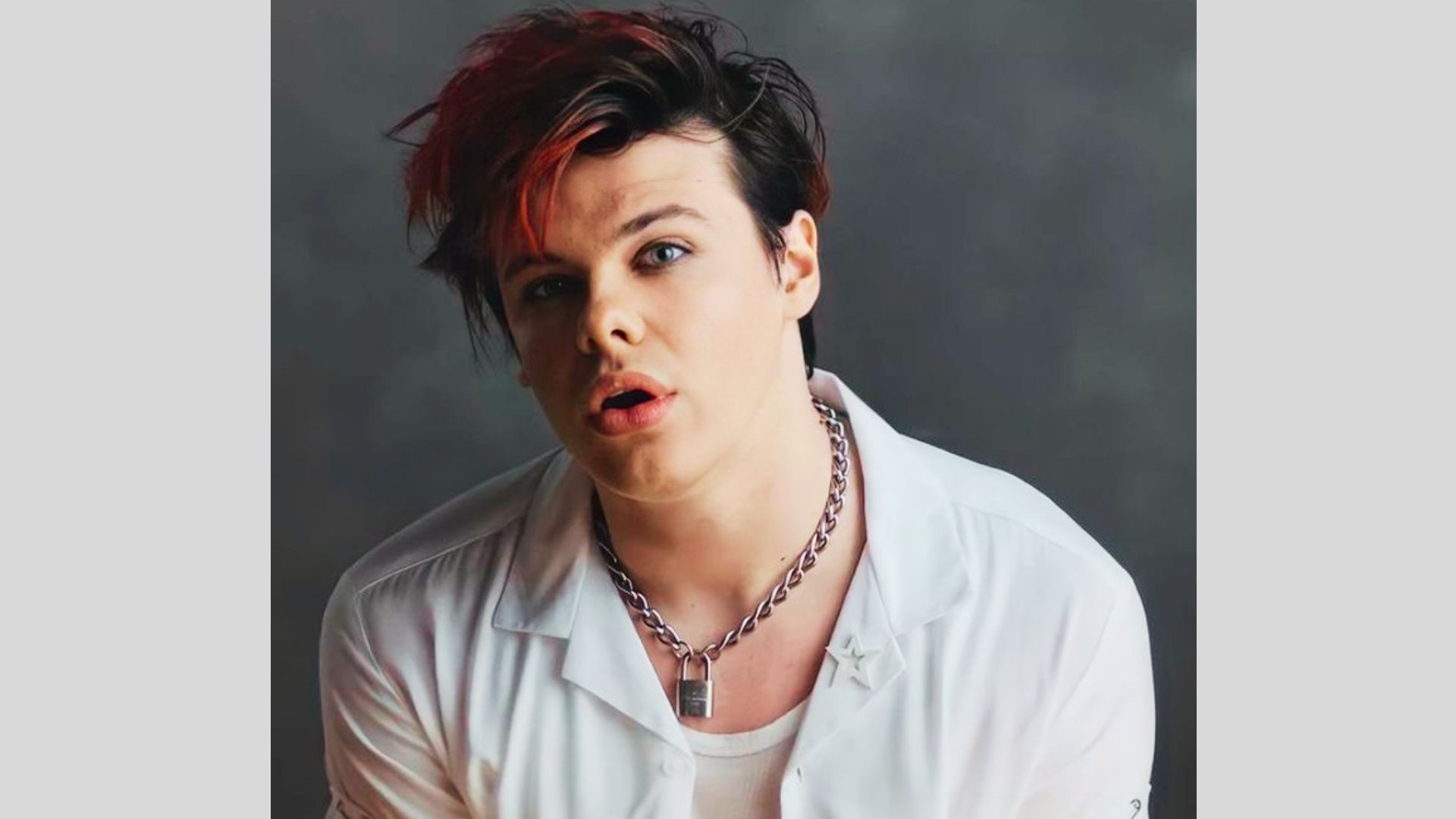Yungblud with a choppy shag-mullet featuring bold red streaks in the fringe.