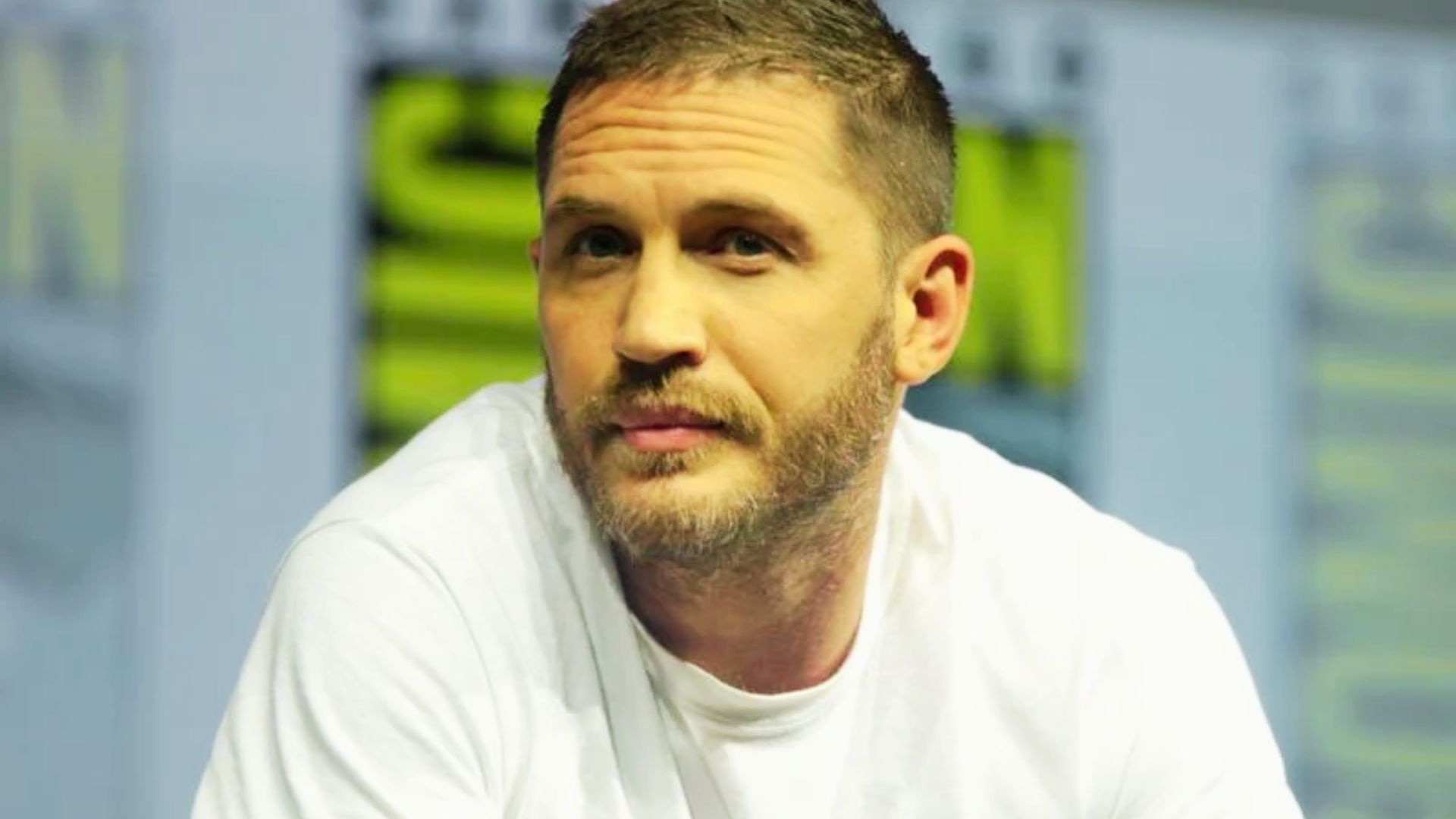 Tom Hardy with a short spiked top and high skin fade, giving an edgy military vibe.