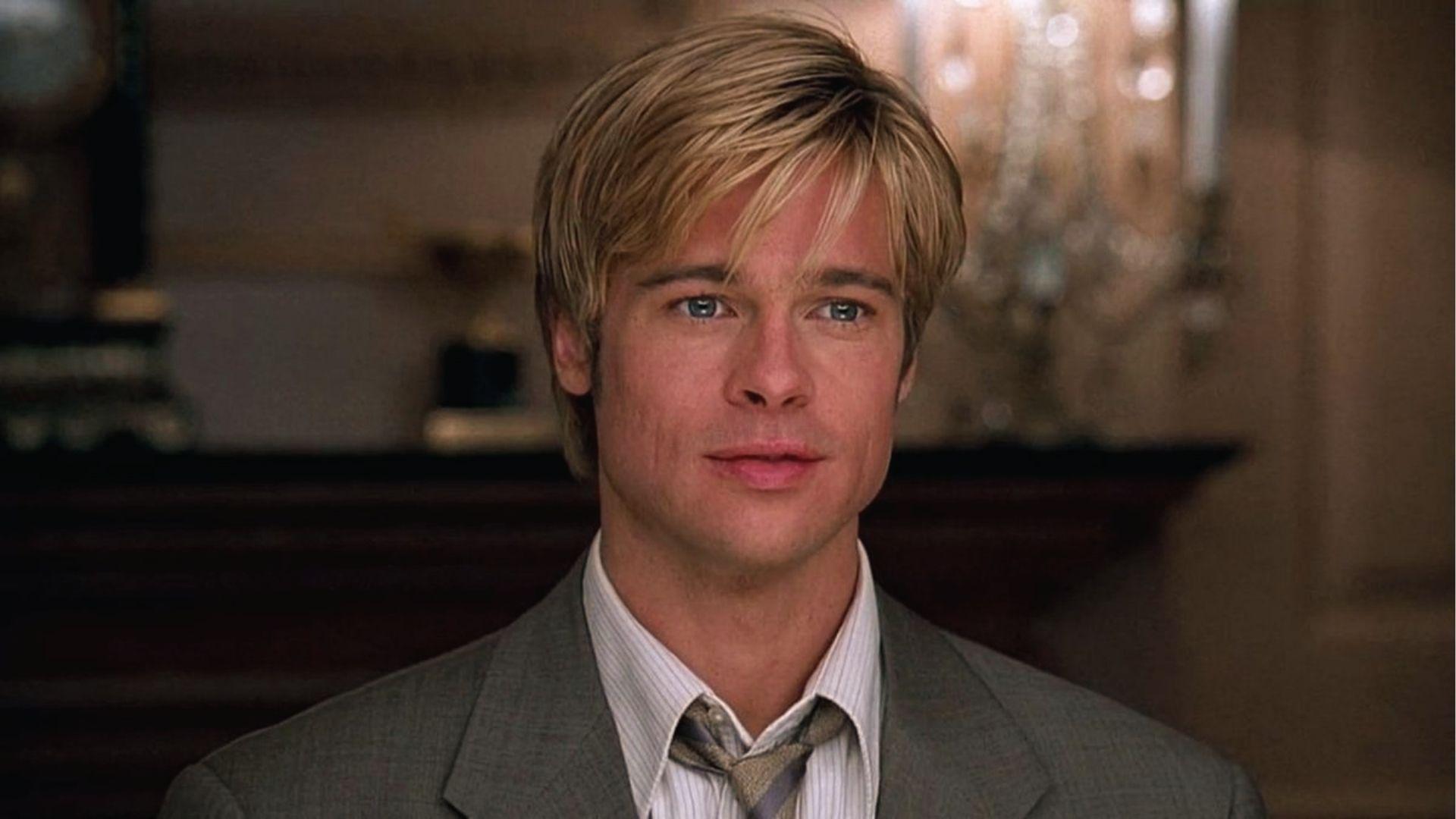 Brad Pitt with blond layered medium hair in gray suit and loose tie, close up portrait