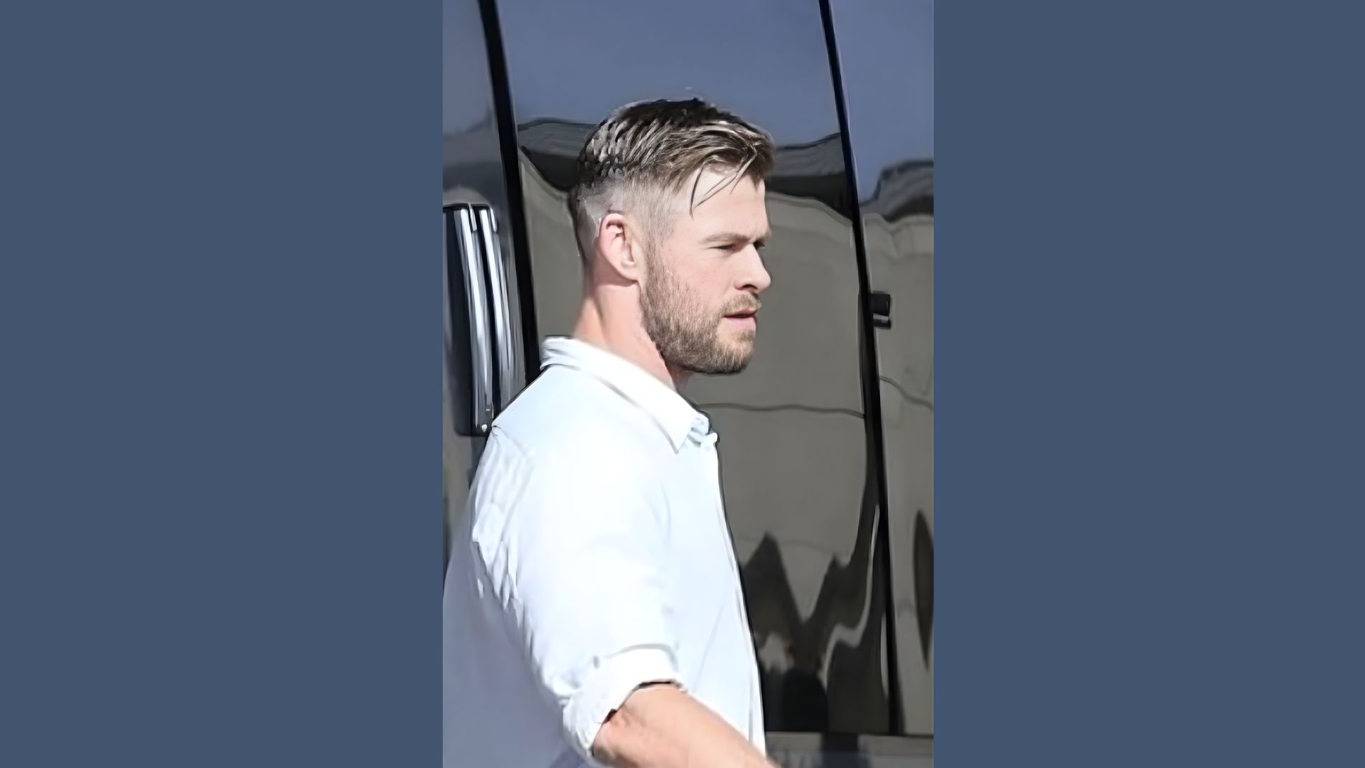 Chris Hemsworth with a beard and white shirt , sporting a high fade haircut with a short top.