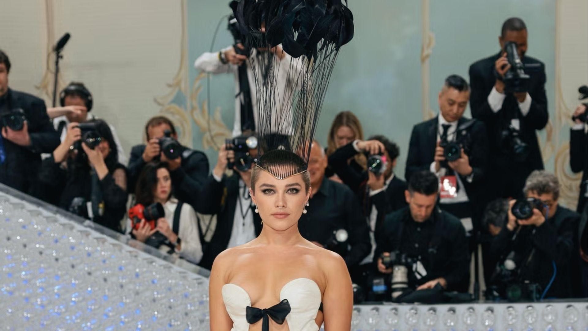 Florence Pugh commands the Met Gala in white cutout gown with a towering feather headpiece.