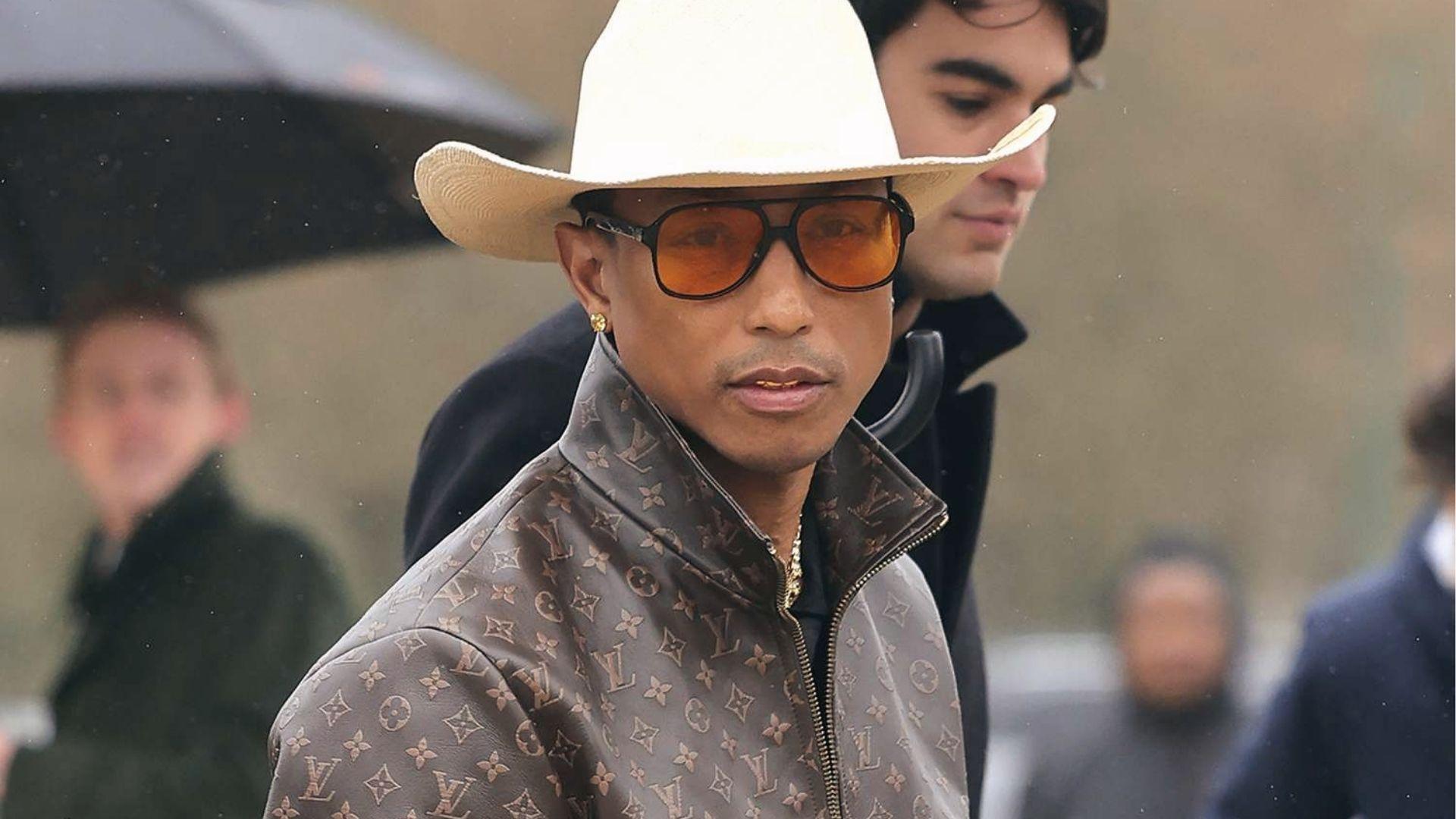 Pharrell Williams rocks LV monogram jacket, white cowboy hat, orange tinted shades