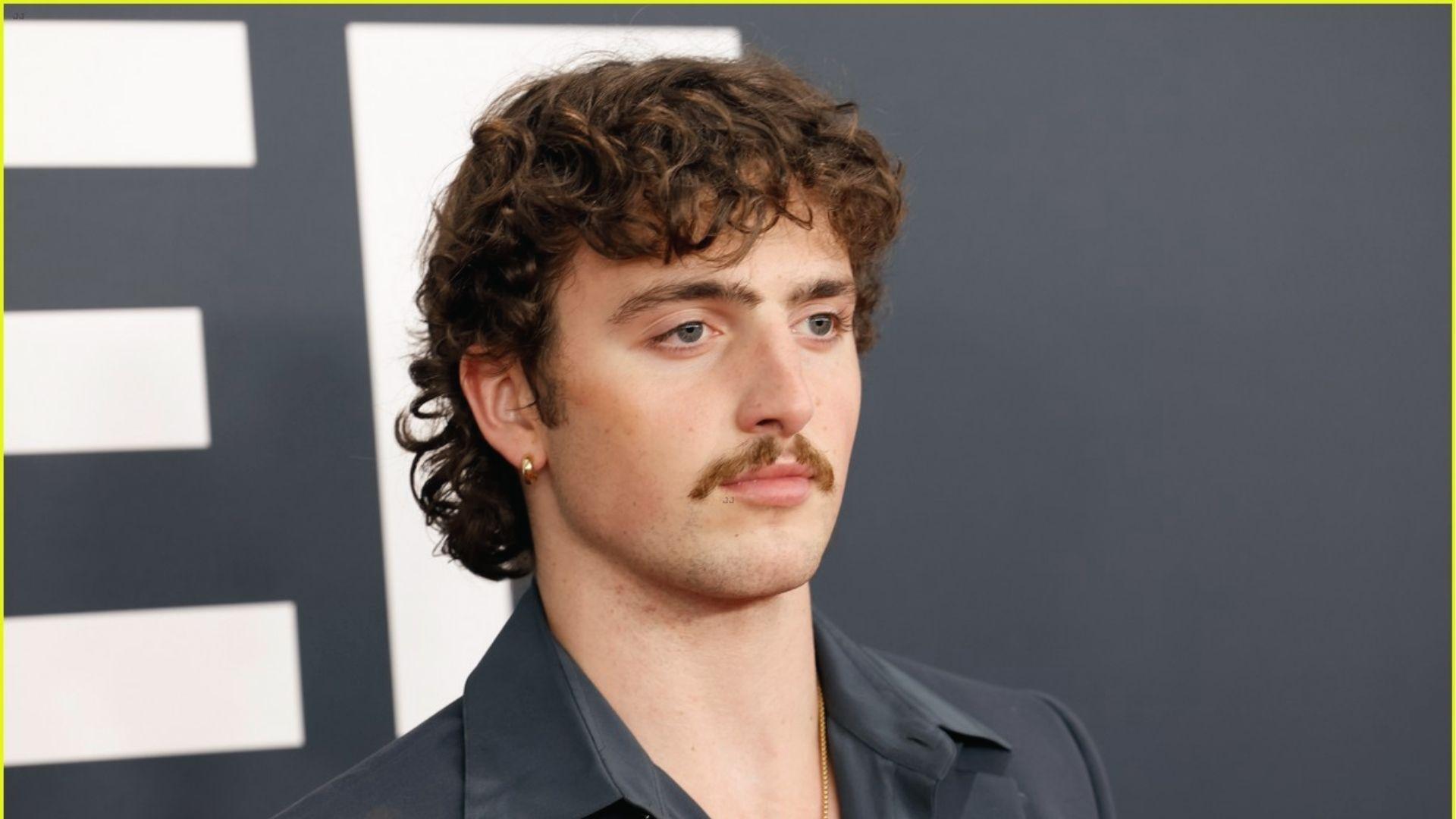 Benson Boone red carpet shot featuring loose curly mullet style and tapered sides.