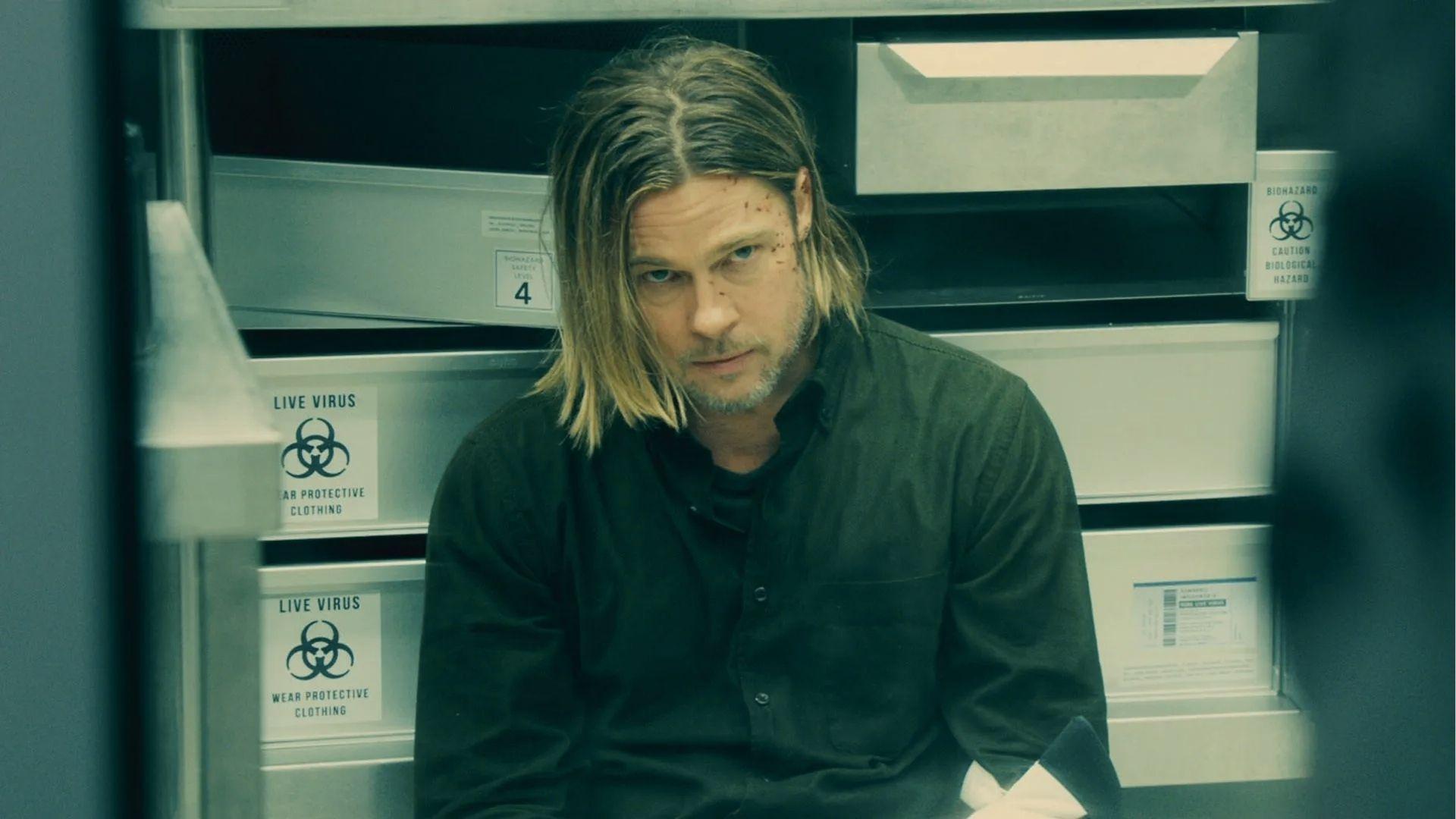 Brad Pitt in World War Z, long center-parted hair, black shirt, cuts on face in lab