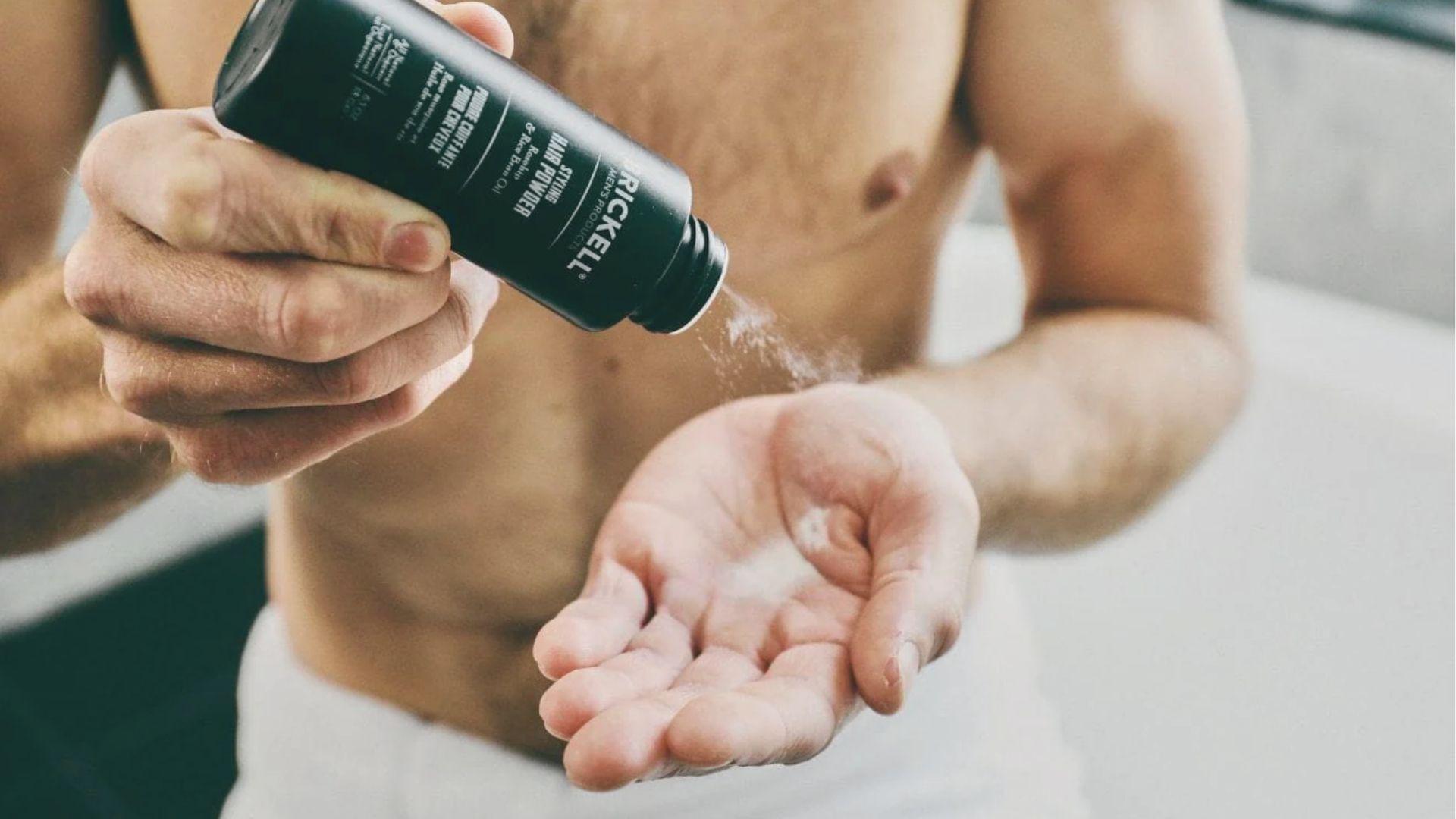 Styling powder is sprinkled into the palm to add matte volume and grit to hair.