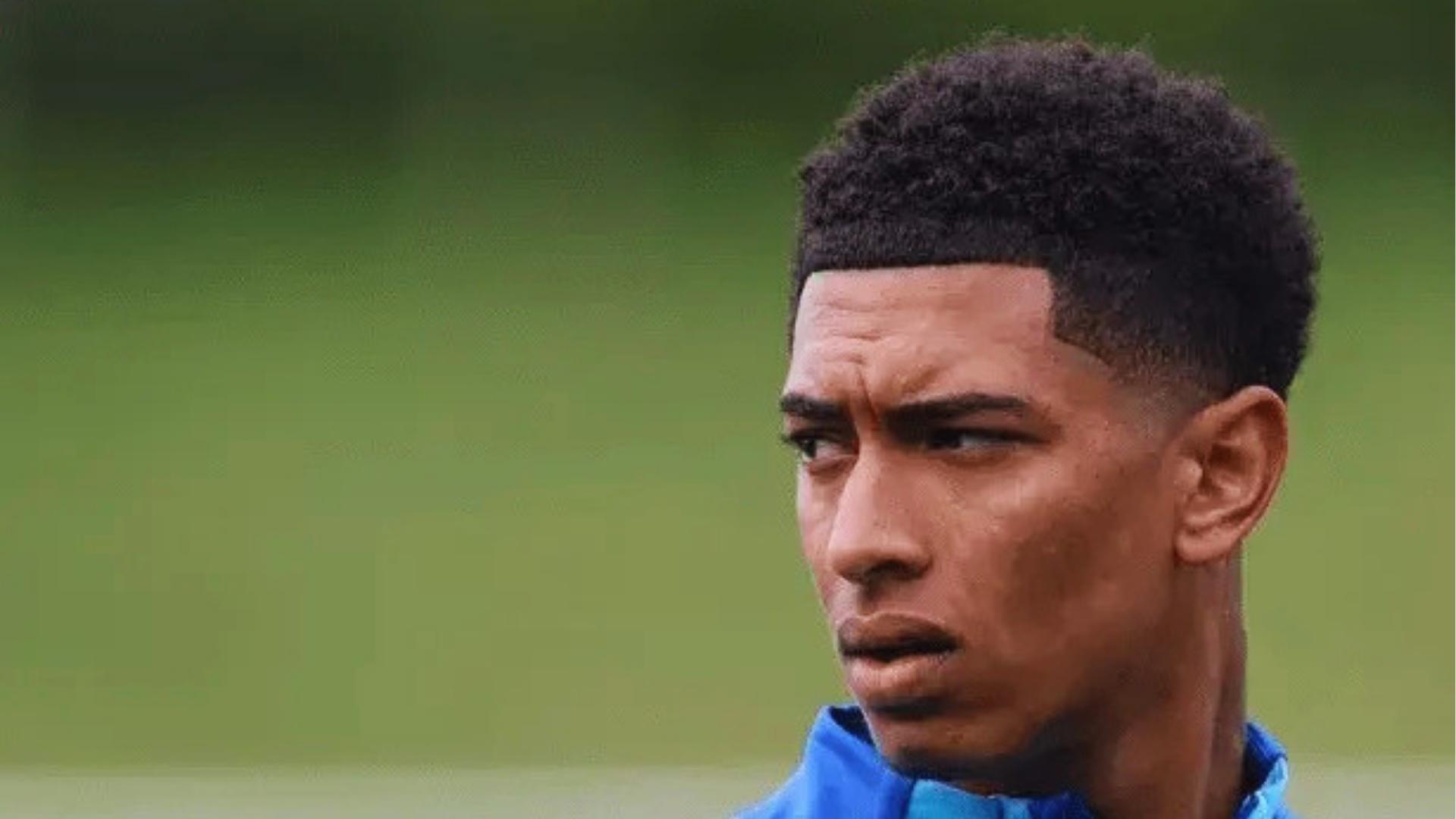 Side profile of Jude Bellingham’s high-top curly afro with a crisp lineup and mid fade, popular with modern men.