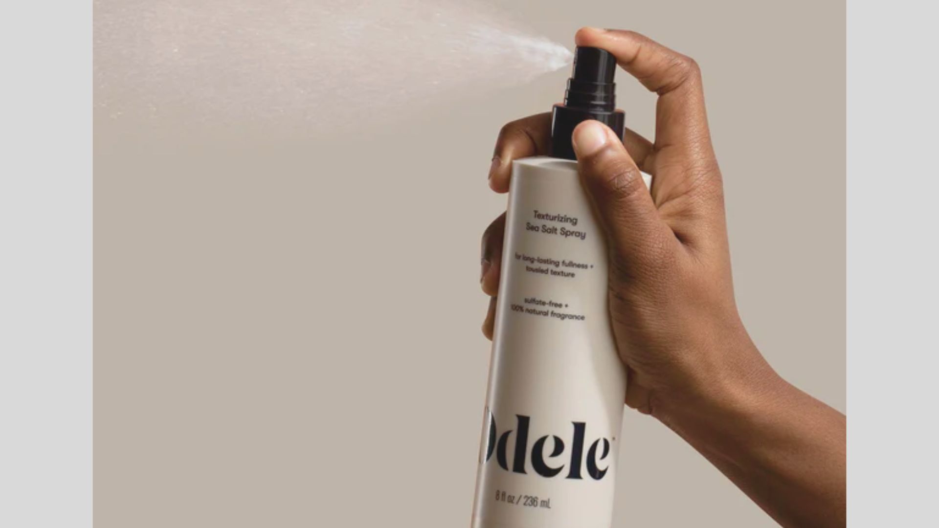 Hand spraying texturizing sea salt spray to build long-lasting fullness and tousled texture.