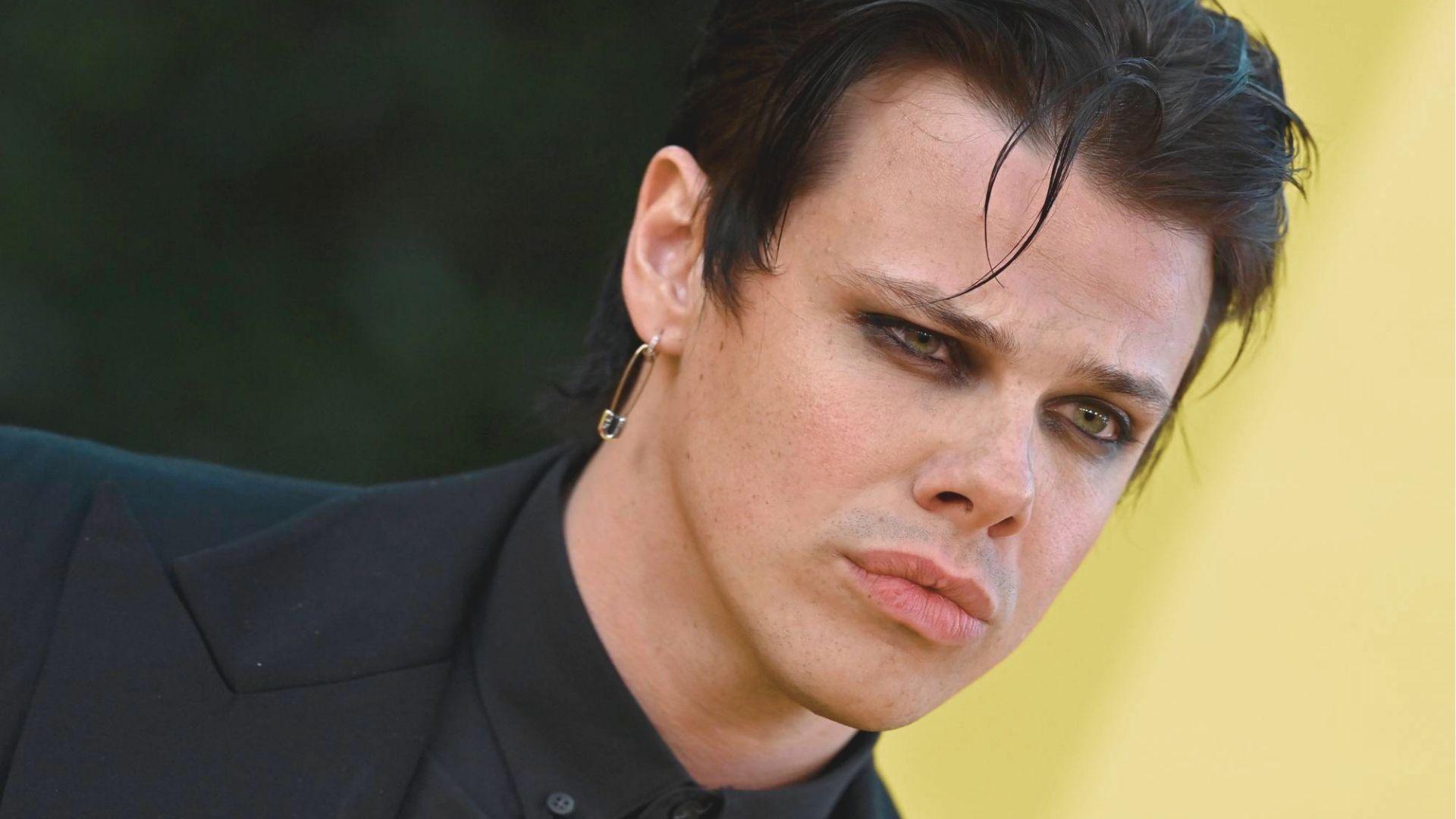 Slicked-back mullet style on Yungblud with wet-look finish and face-framing tendrils.