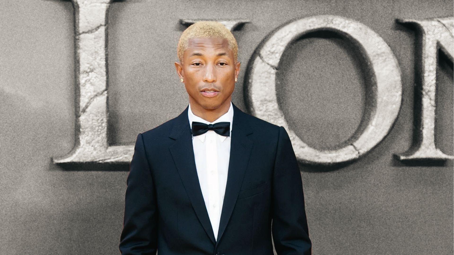 Pharrell Williams in sleek black tuxedo with bow tie at premiere, bleached buzz cut