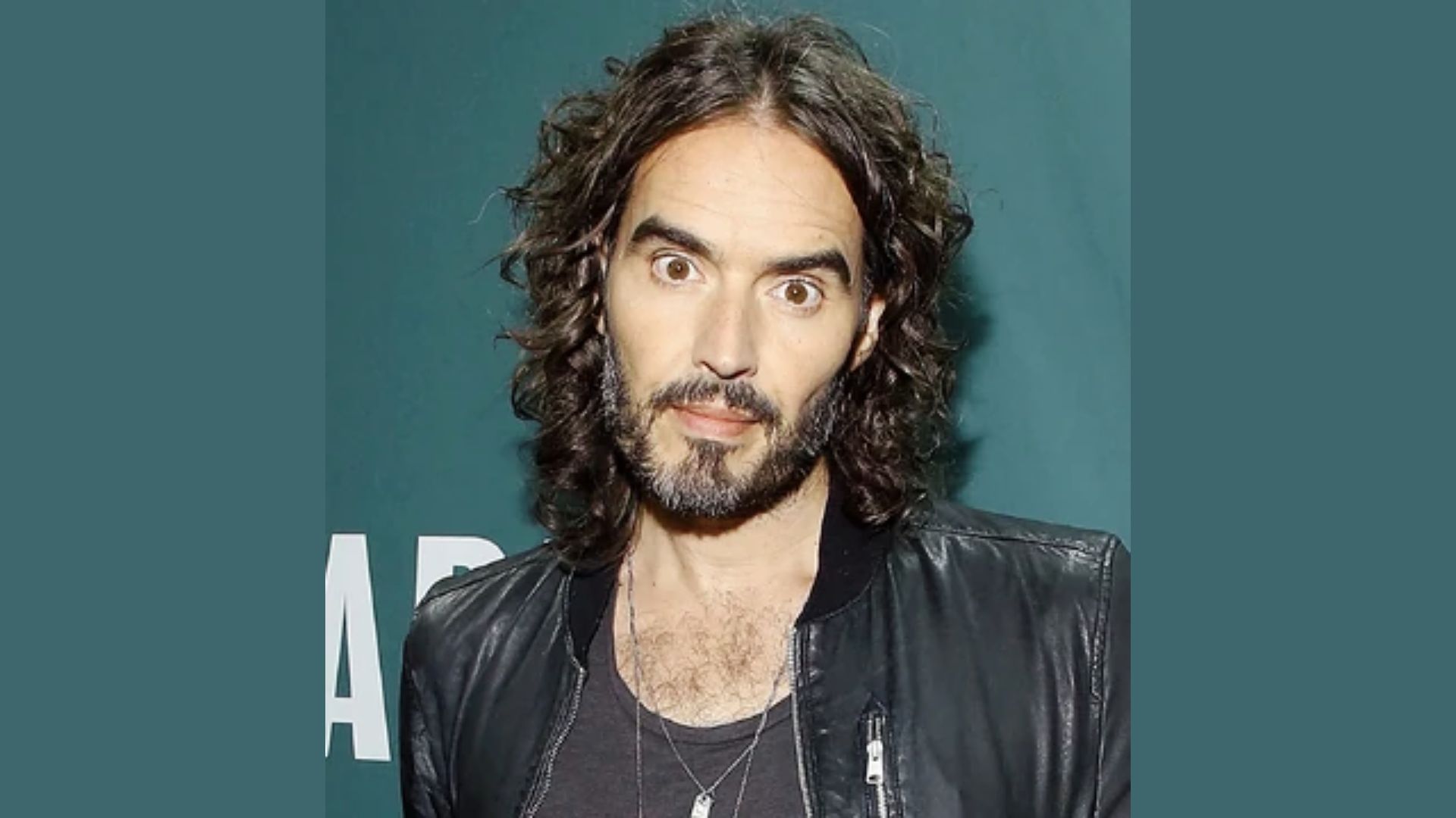 Russell Brand showcasing a stylish short curly shag hairstyle.