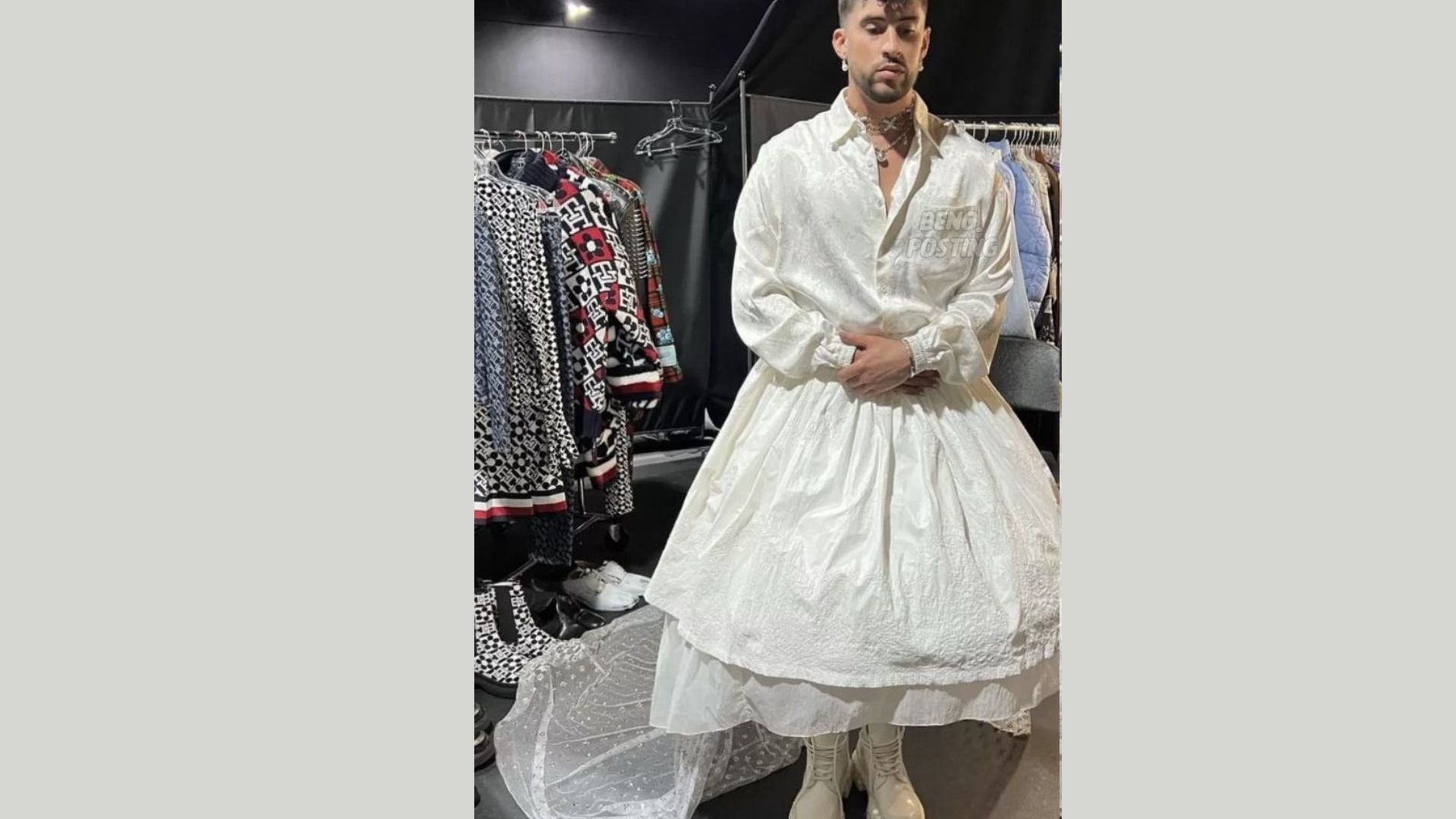 "A person wearing a voluminous white dress and boots stands confidently in a stylish closet. Fashionable clothing hangs on racks behind them."