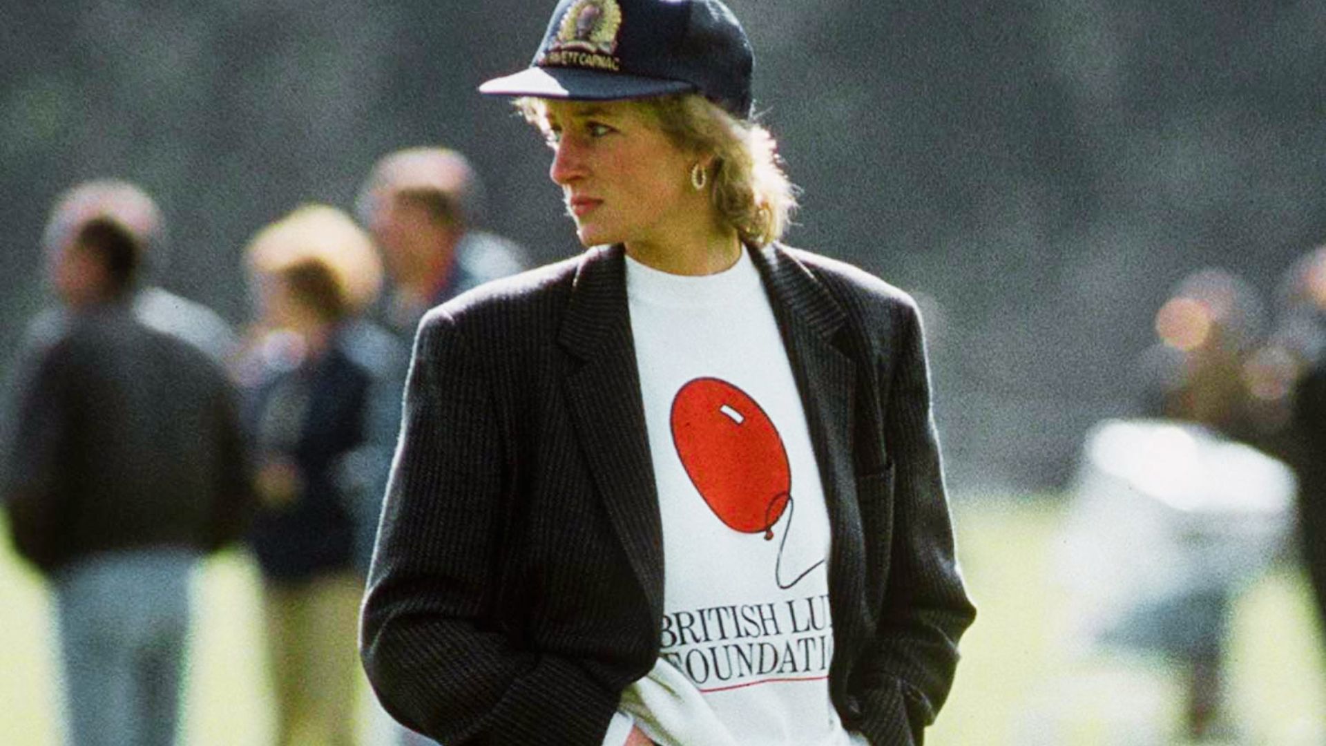 Princess Diana wears a pinstripe blazer over a British Lung Foundation tee and baseball cap.