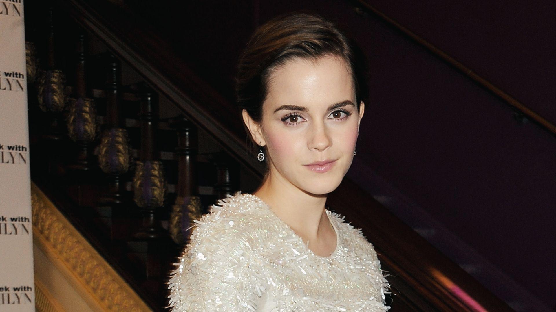 Emma Watson wears a grown-out pixie cut styled back in a beaded white dress.