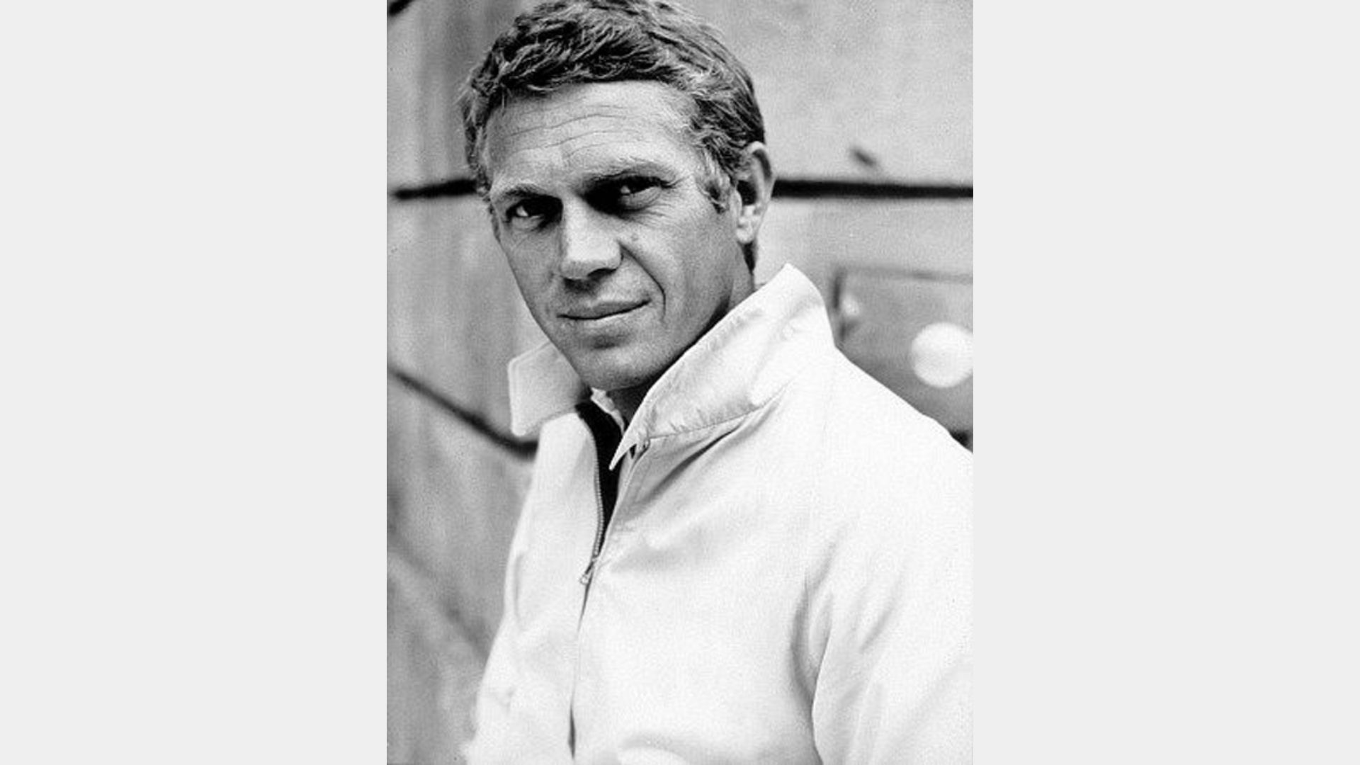 "A man in a white shirt poses for a photo, smiling and looking directly at the camera."