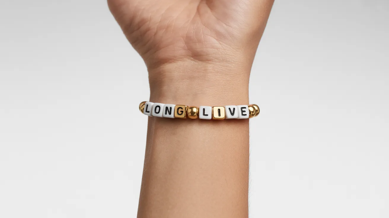 wrist shot with gold and white beaded bracelet displaying LONG LIVE in bold cube letter beads clearly readable.