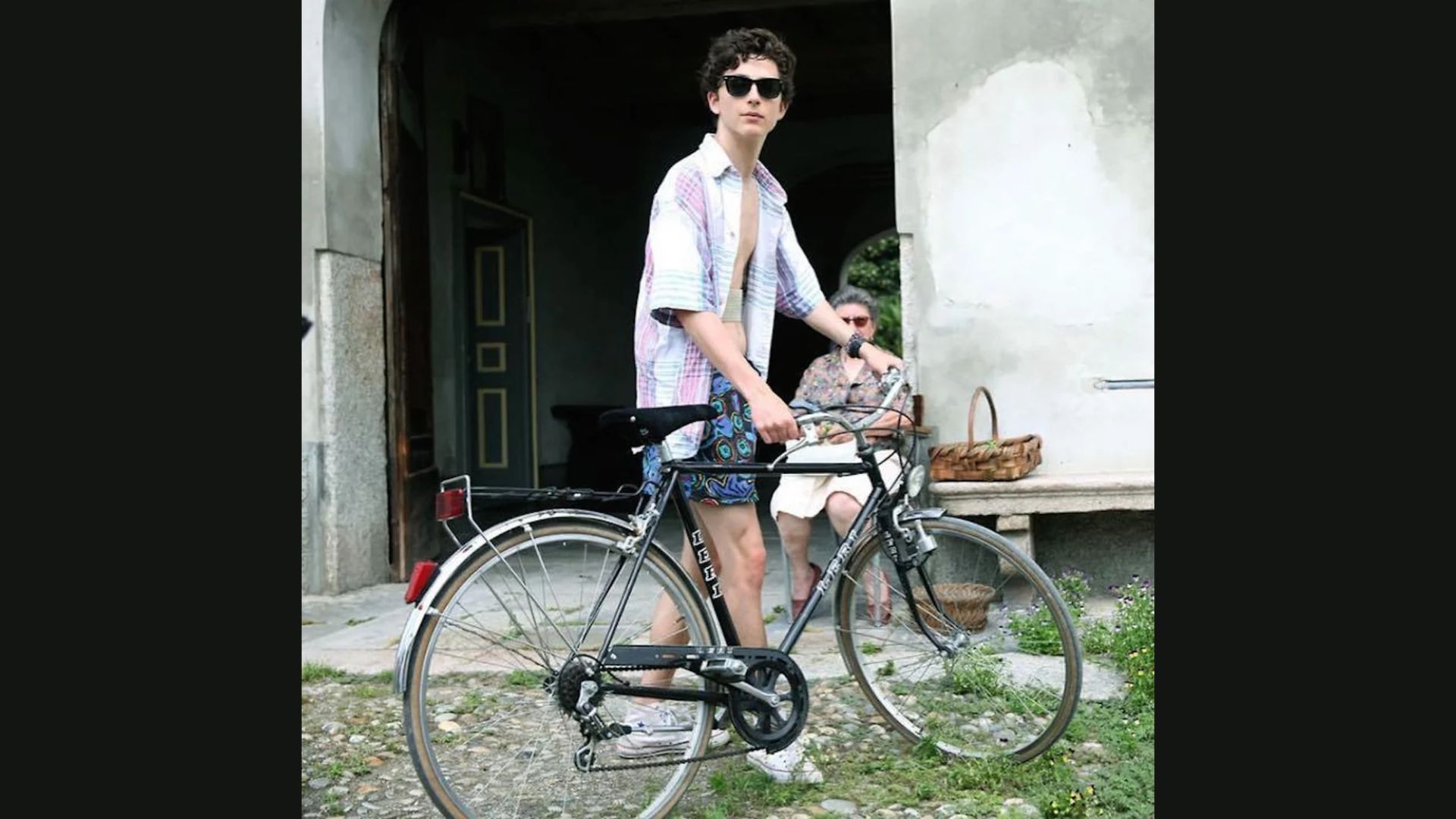 A man wearing shorts and a shirt rides a bicycle along a path