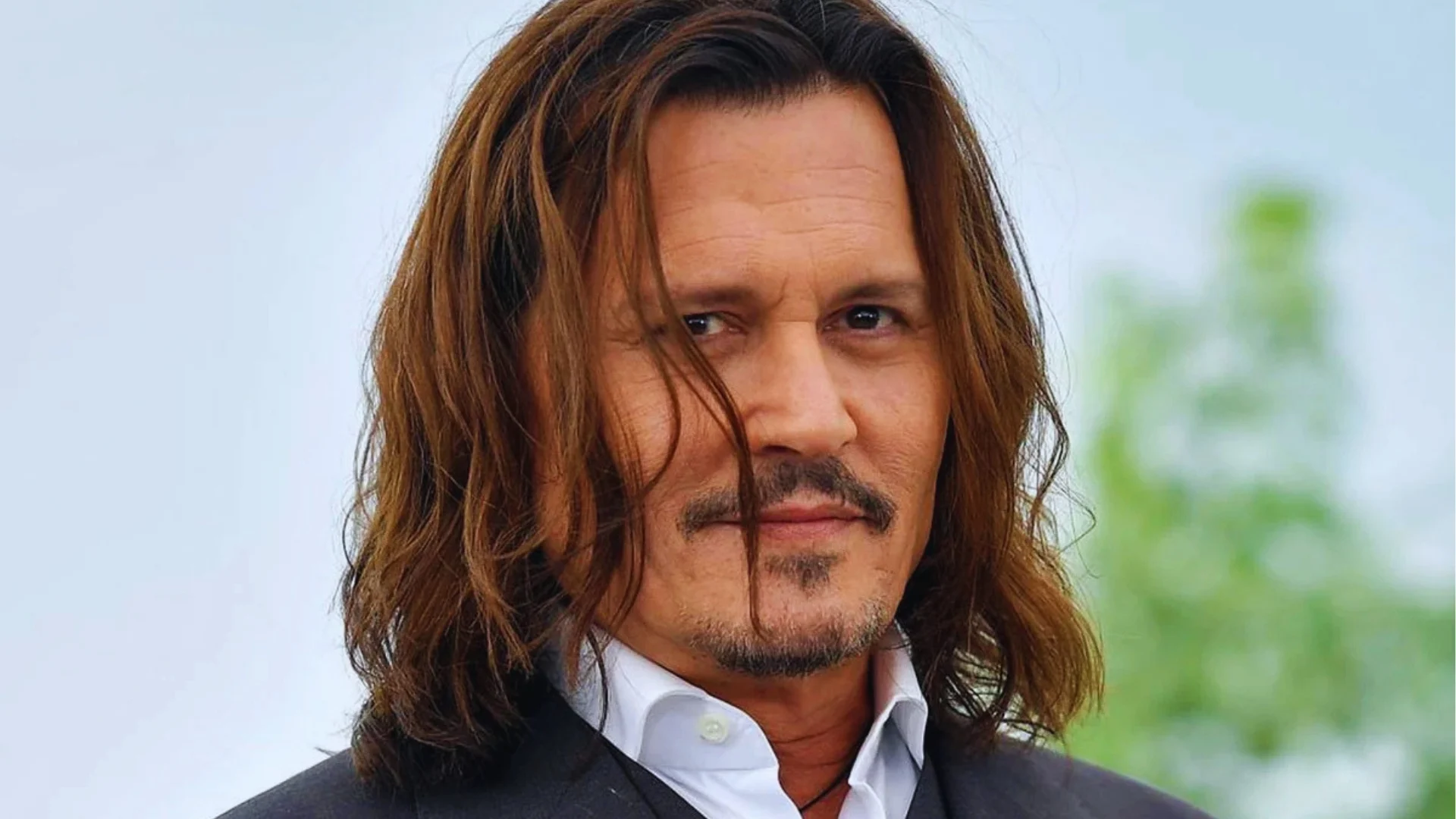 Wild natural long rockstar waves on Johnny Depp with loose texture, rugged look, and dramatic face close-up