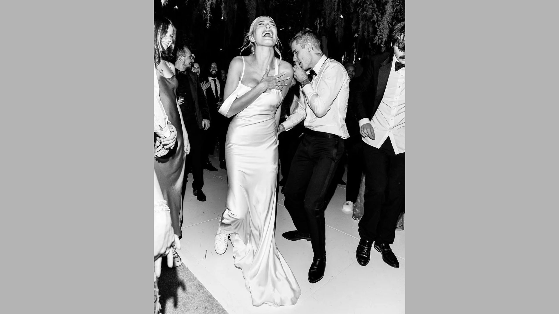 A man and woman joyfully dancing together at a wedding celebration, surrounded by festive decorations and guests.
