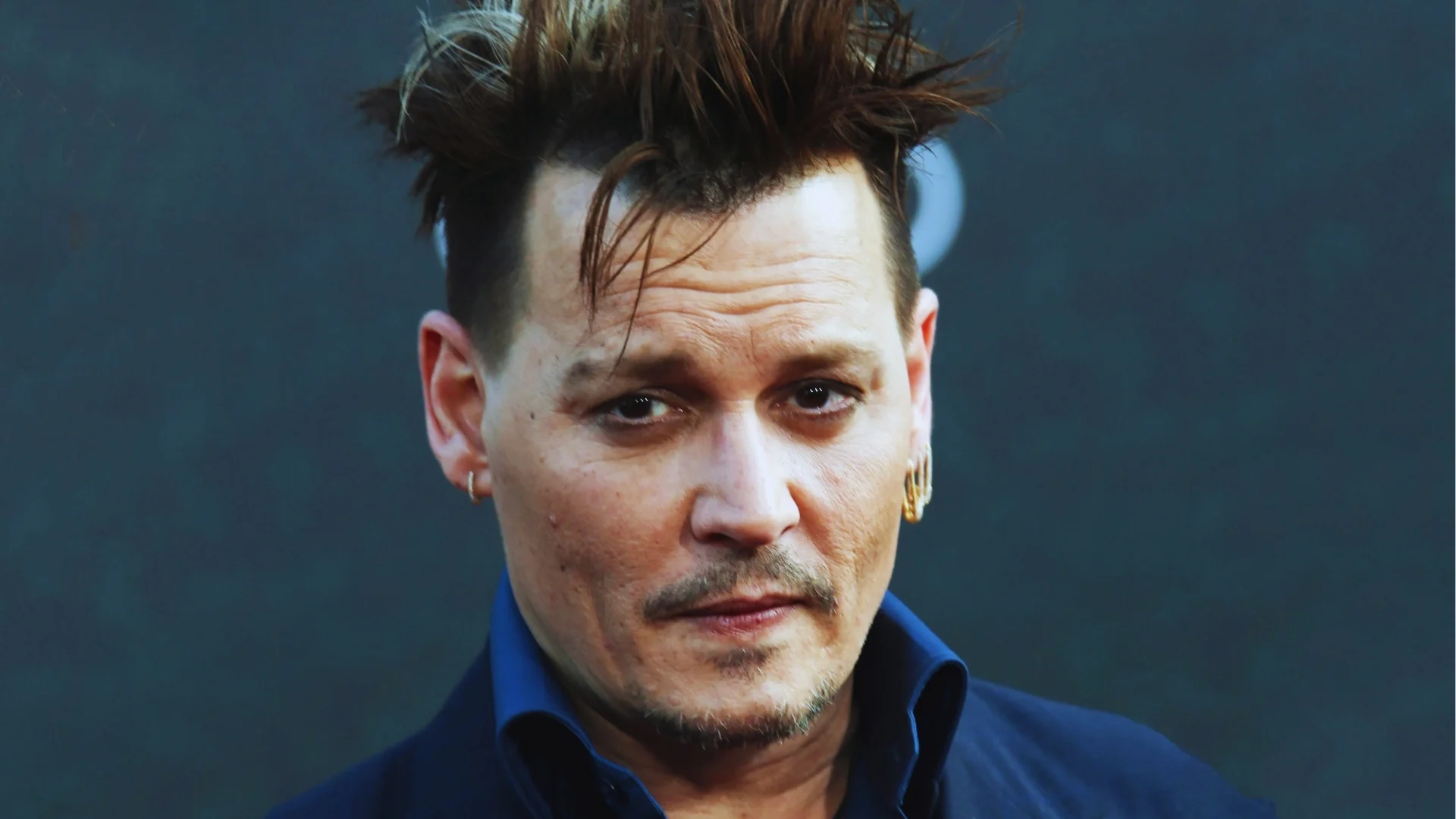 Short sides with messy brushed-up top on Johnny Depp with textured volume, casual finish, and close-up face