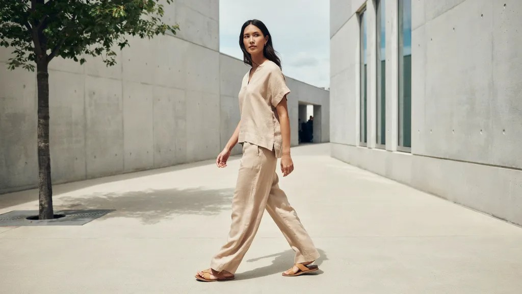 Tall woman wearing full-length wide leg linen pants with matching top.