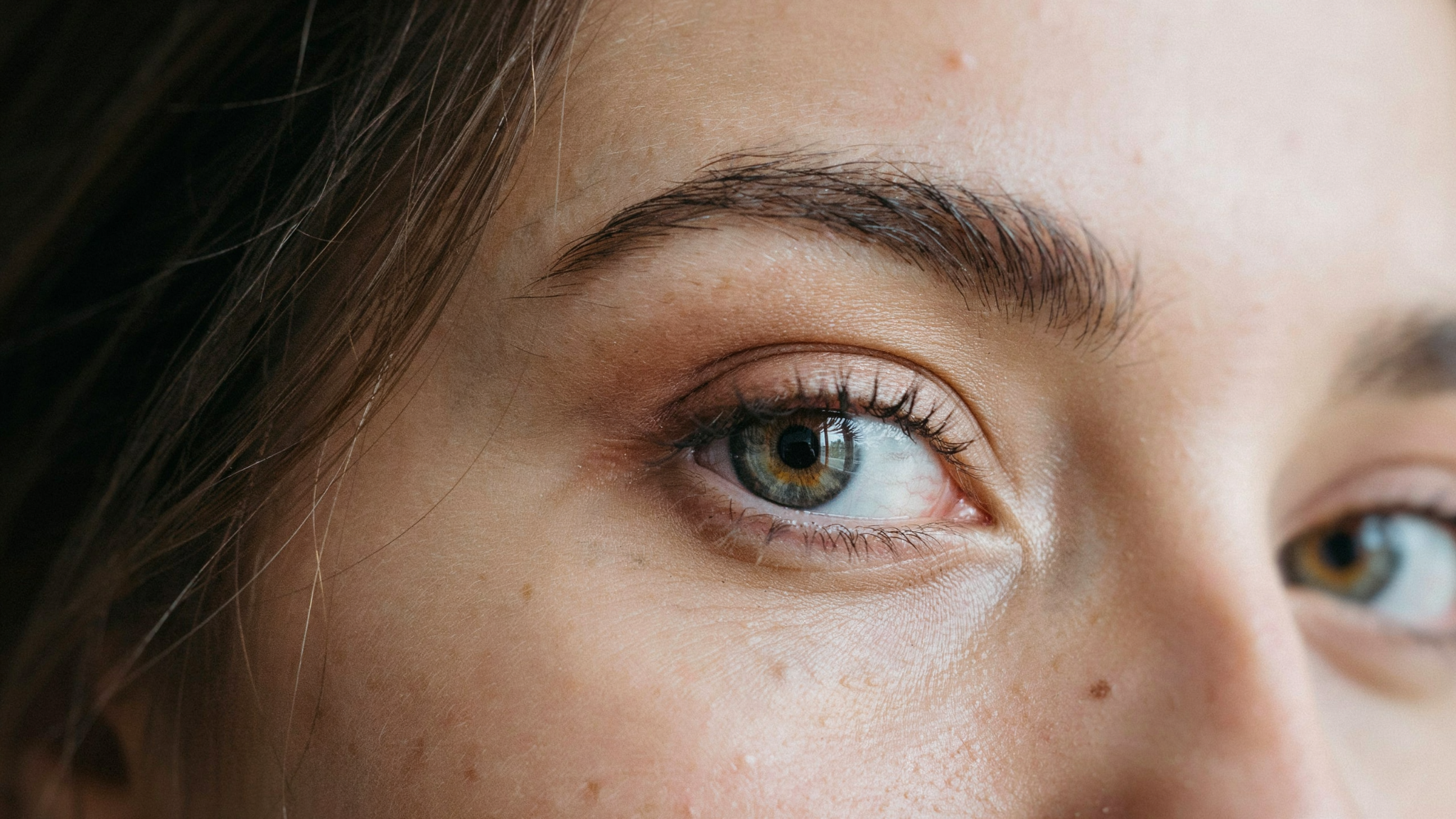 natural eye makeup with soft mascara and lightly defined brows using fine strokes creating a clean minimal look with a balanced polished appearance.