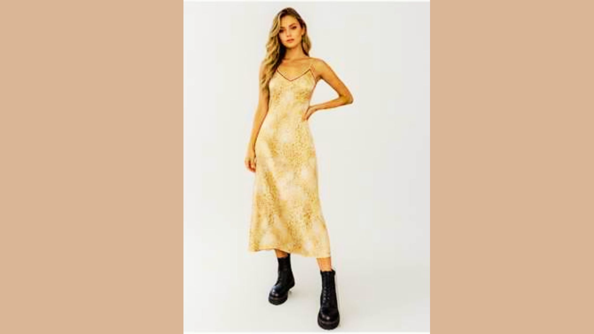 Model in a gold-toned retro slip dress with delicate straps and subtle print, styled with chunky combat boots.