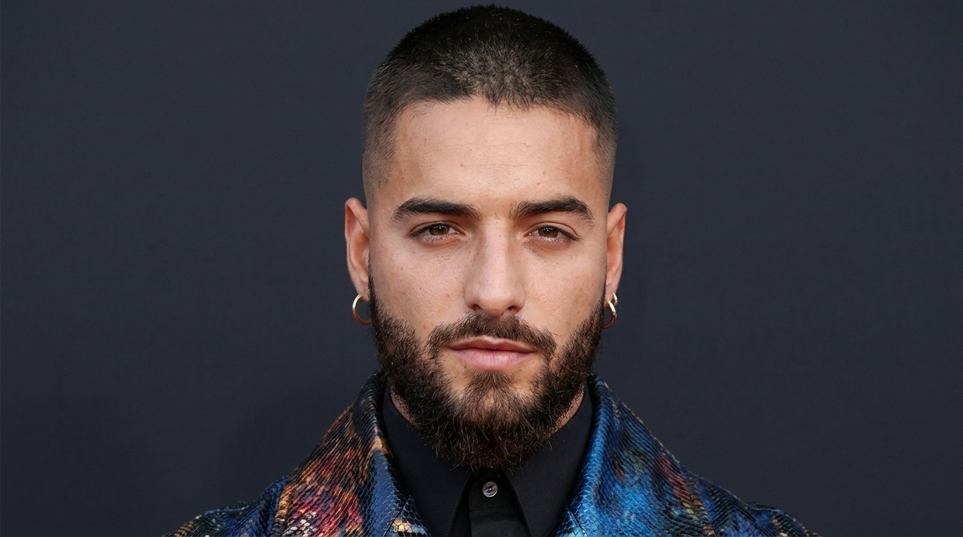 Maluma with short dark buzz cut and full beard wearing colorful jacket