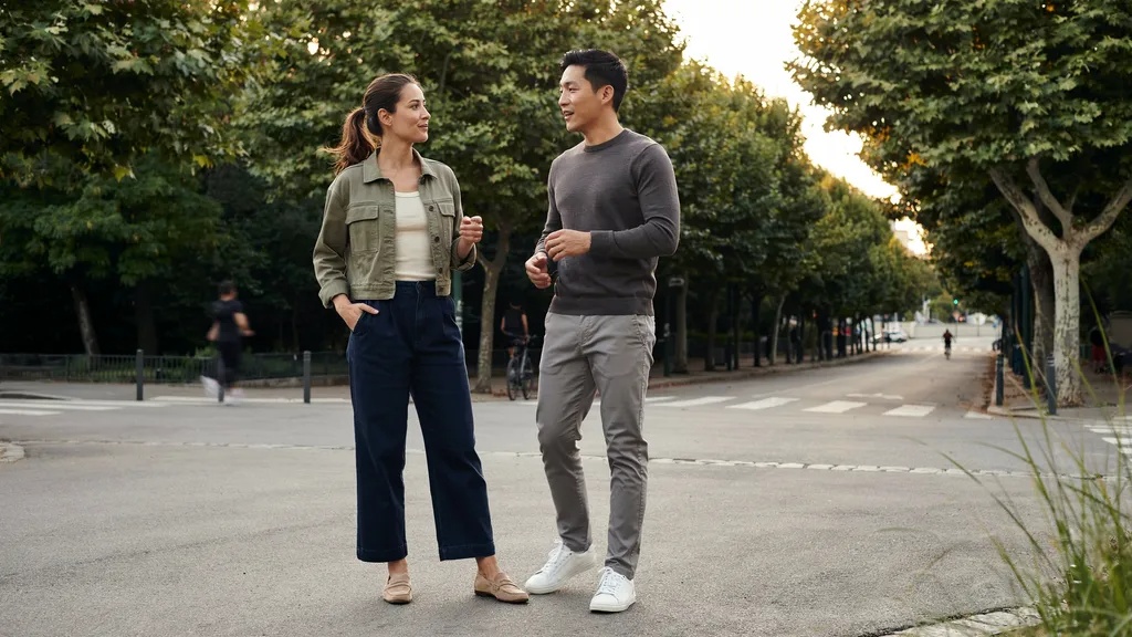 Confident man and woman with broad shoulders posing in stylish outfits.