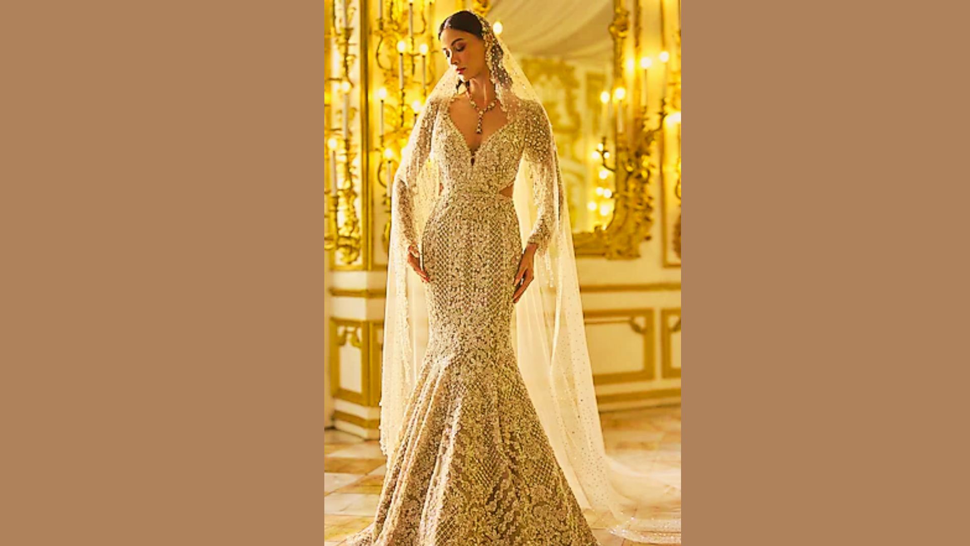 A bride in a heavily beaded mermaid-cut gown with long sheer sleeves and a delicate veil.