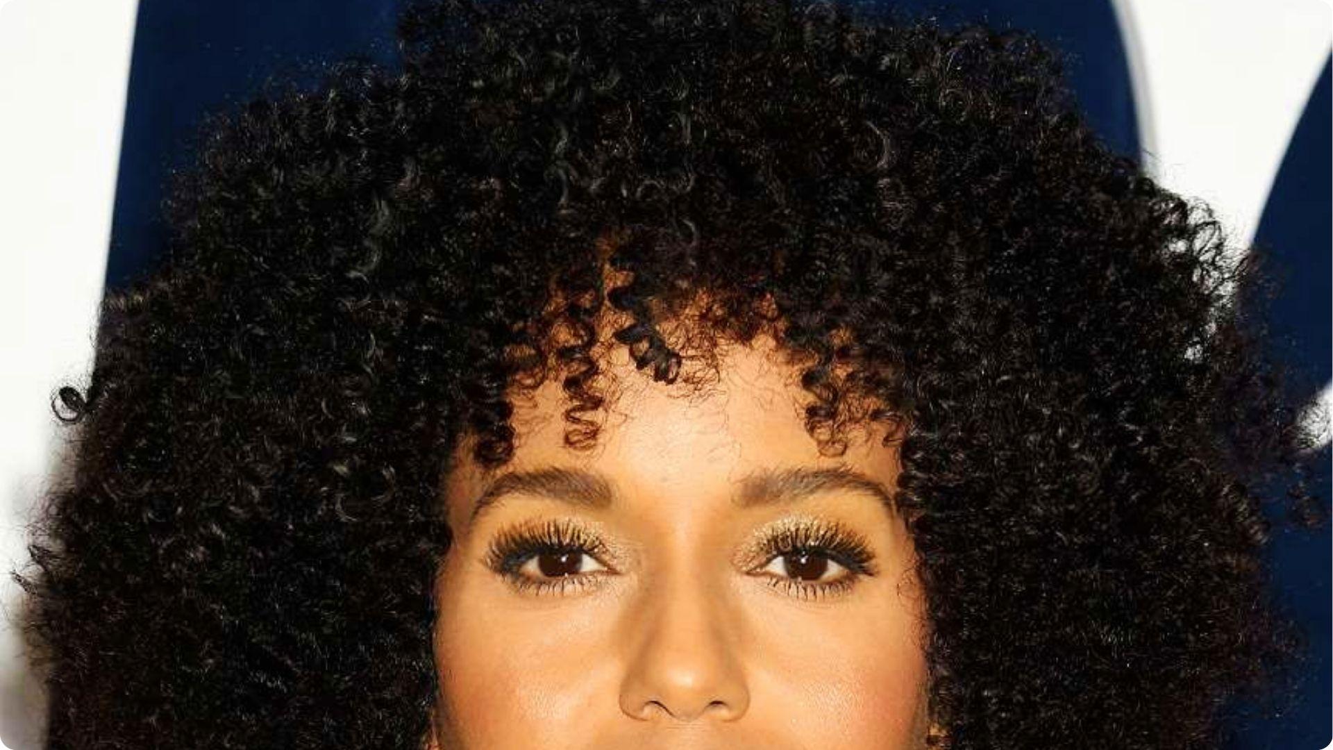 Close up of Kerry Washington with full voluminous natural curly bangs and glittery eye makeup detail