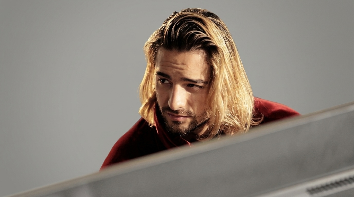 Maluma with long blonde bob hair slicked back in red shirt